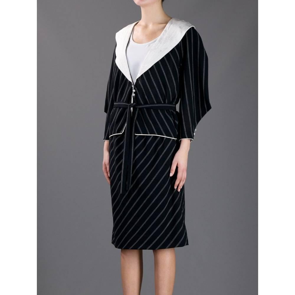 Emanuel Ungaro black wool jacket with white pinstripe pattern. White wide collar with jacquard motif, front button closure, long structured sleeves and waist belt.

Size: 10 UK

Flat measurements
Height: 57 cm
Bust: 53 cm
Shoulders: 42 cm
Sleeves: