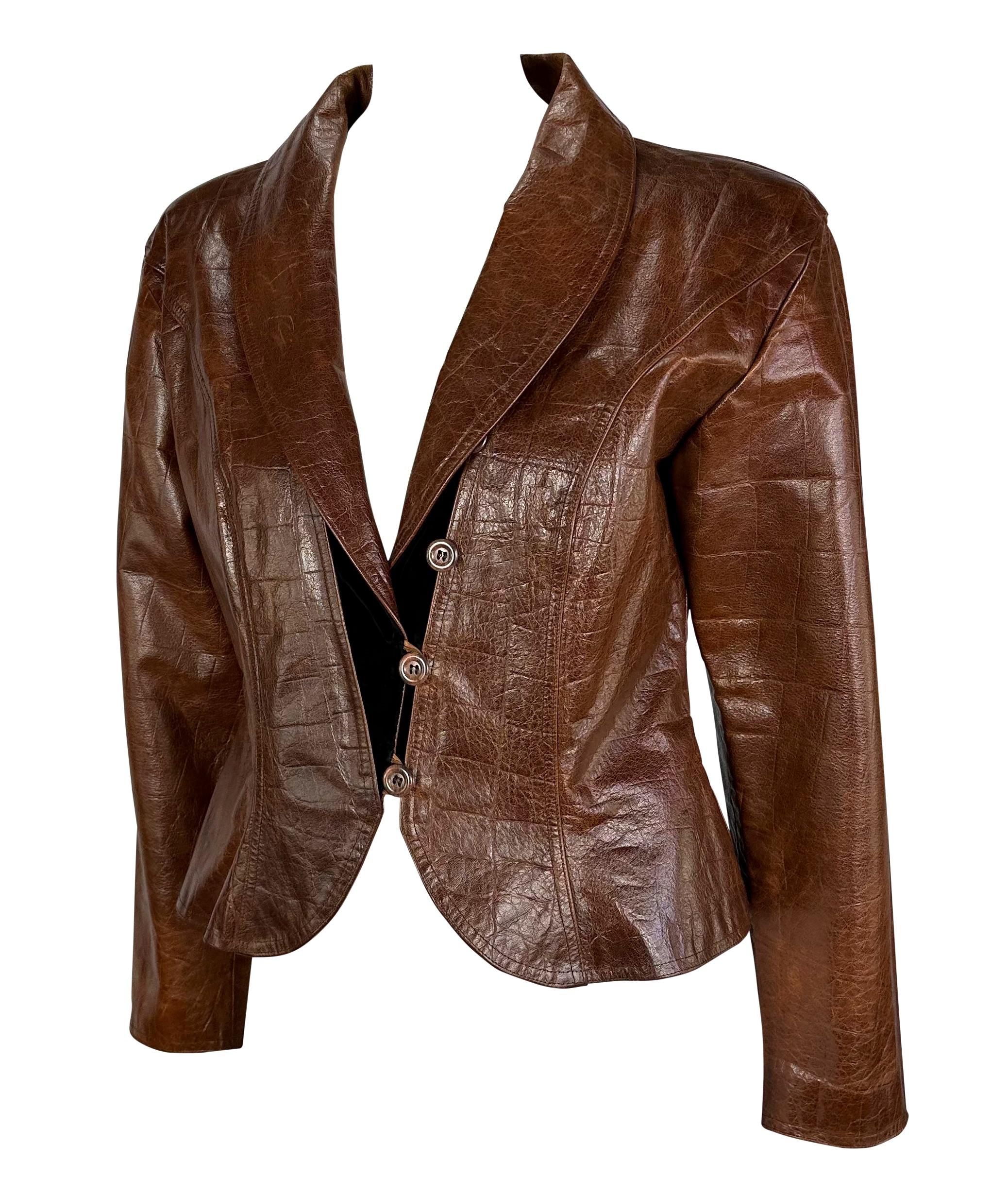 Voici une fabuleuse veste en cuir marron embossé au crocodile d'Emanuel Ungaro. Datant des années 1980, cette fabuleuse veste présente un ourlet péplum évasé, des détails en velours noir et un revers en forme de châle. Ajoutez cette fabuleuse pièce