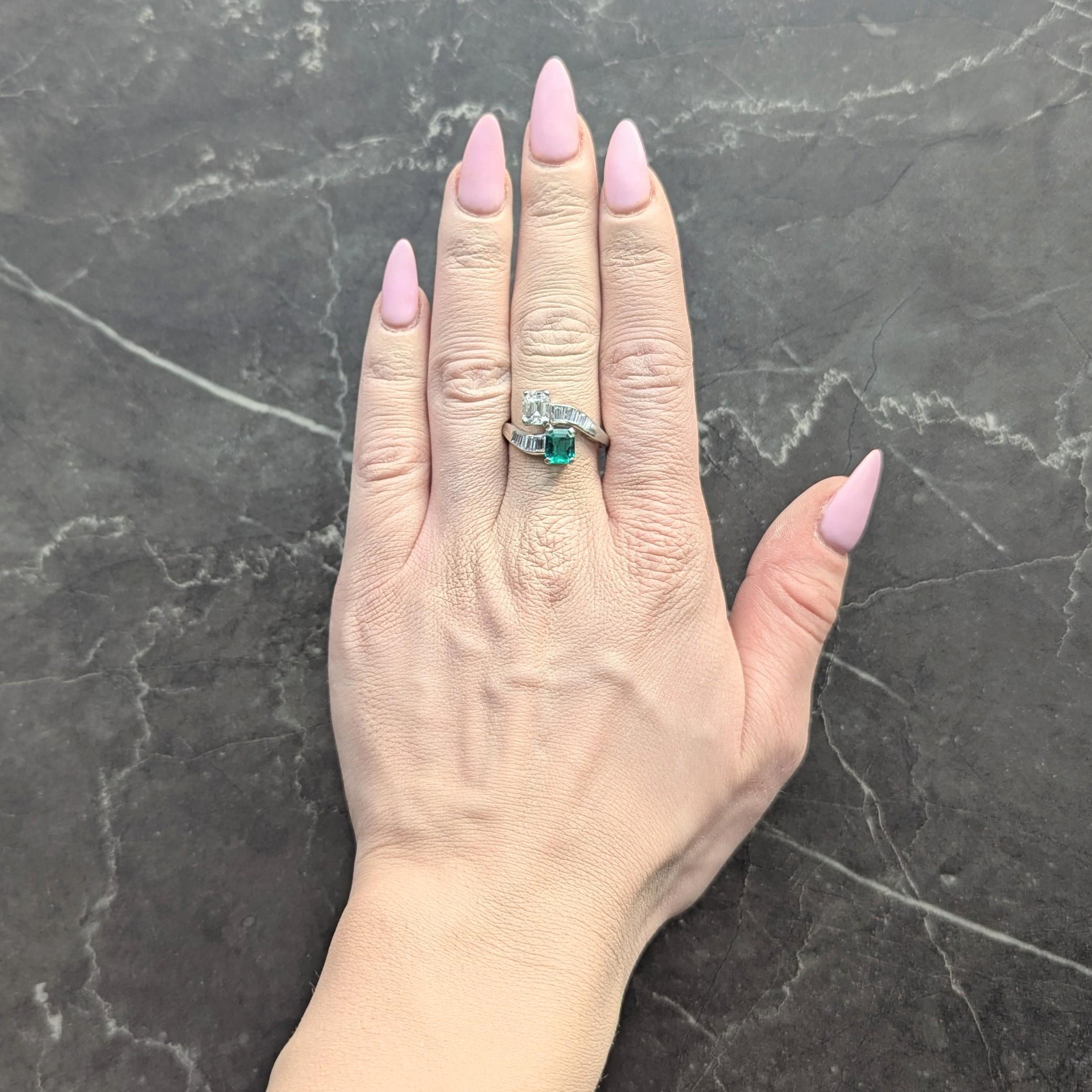 Designed as a bypass style shank terminating with juxtaposed emerald cut emerald and diamond
Emerald weighs approximately 1.02 carat - transparent medium green in color
Diamond weighs approximately 1.08 carat - G color with VS2 clarity
Prong set in