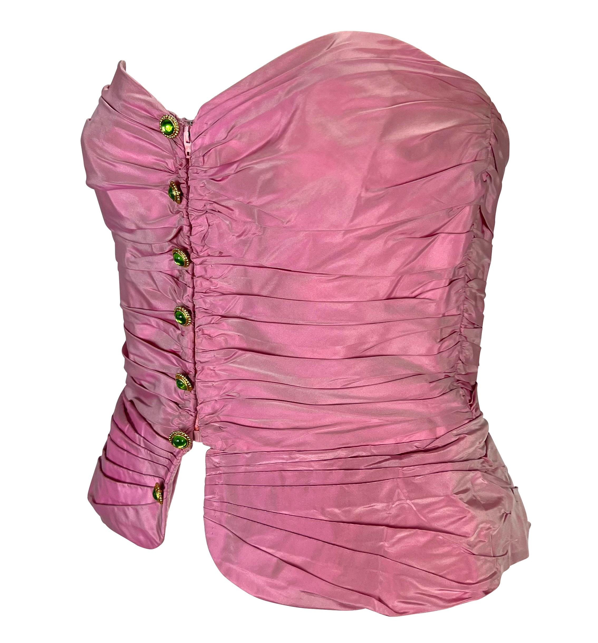 TheRealList presents: a metallic pink Emanuel Ungaro corset bustier top. From the 1980s, this fabulous ruched bustier is covered in a satin pink nylon fabric. The top features a sweetheart neckline, zipper closure at the front, and a row of green