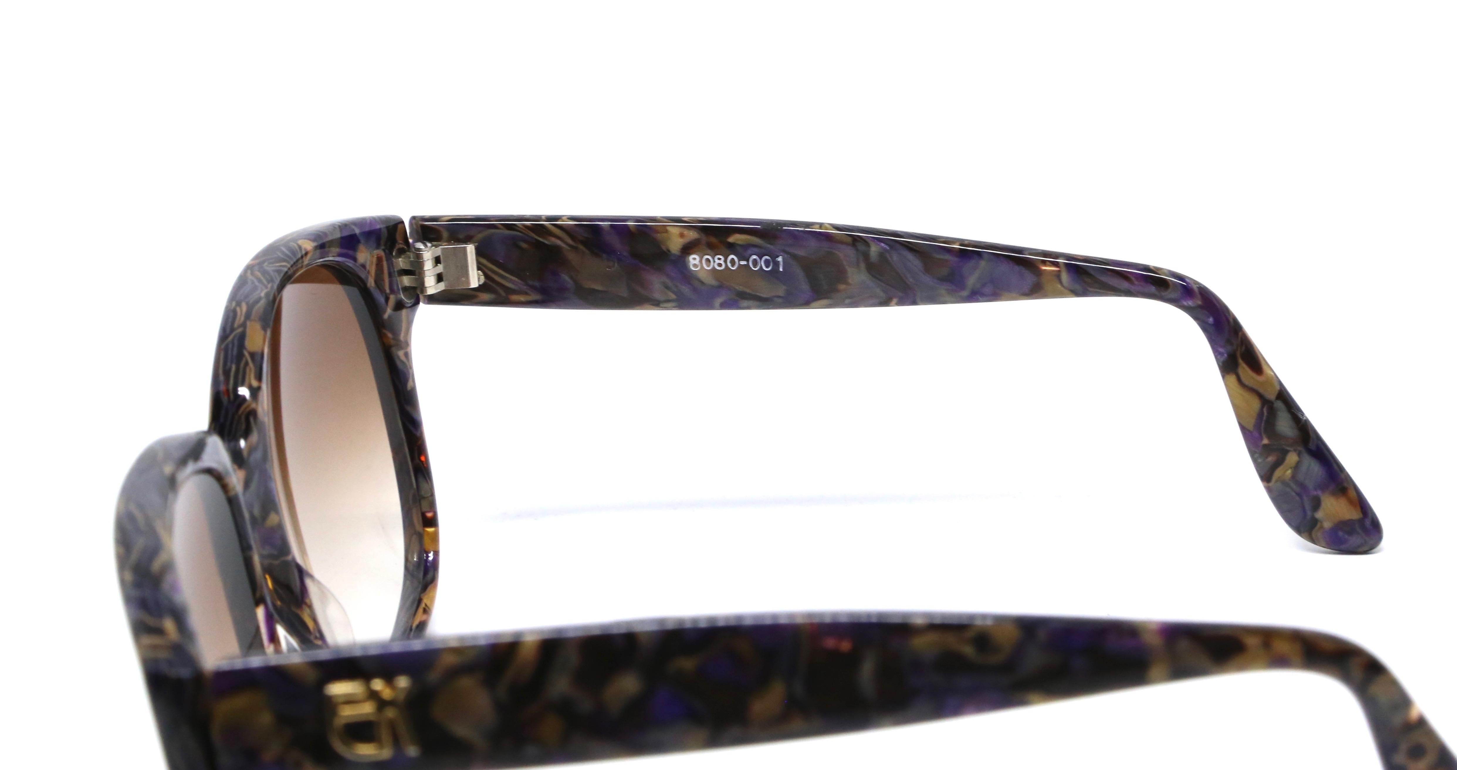 Vivid purple and bronze mosaic sunglasses with gold-toned EK logos at temples and golden brown hued lenses from Emmanuelle Khanh dating to the late 1970's, early 1980's. Oversized frames work well for a medium or larger sized face. Approximate