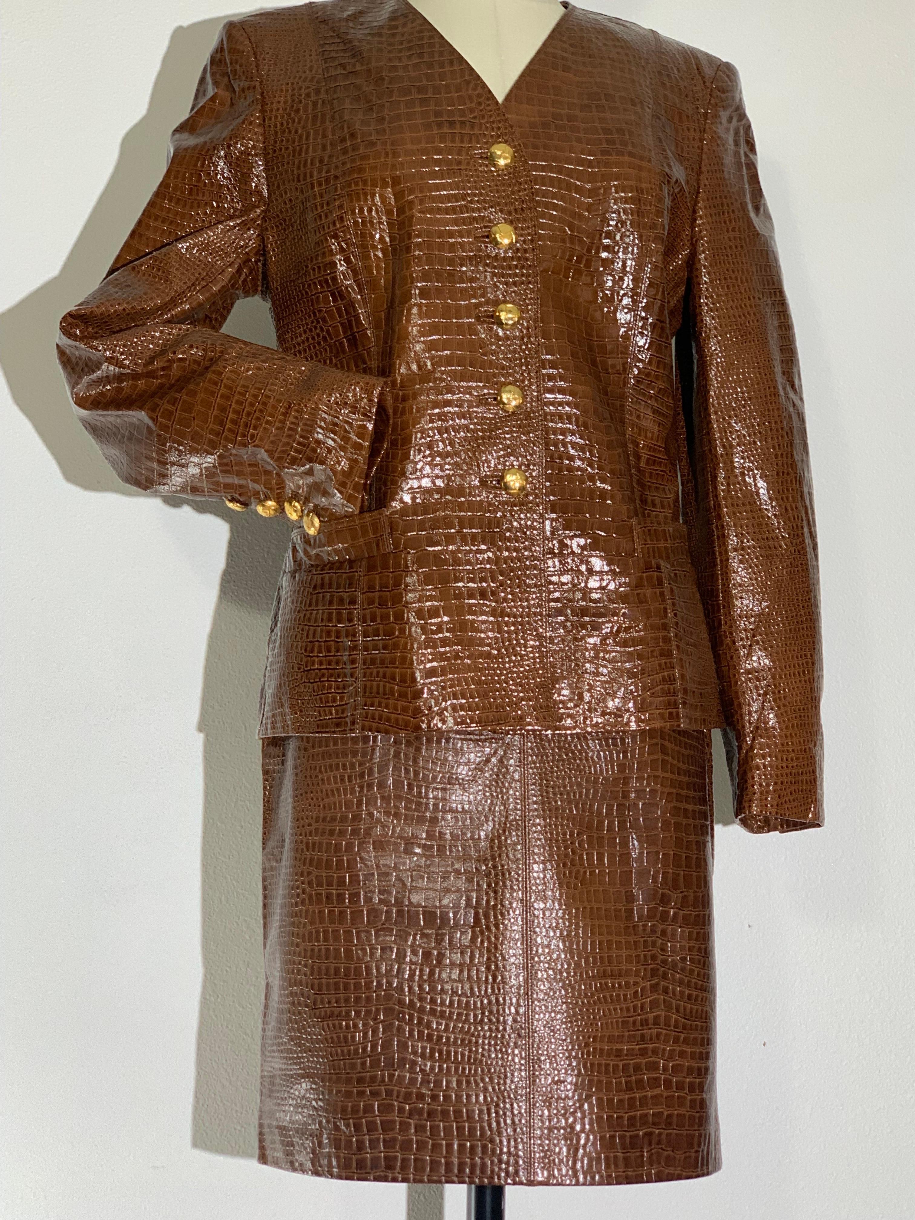 1980s Escada Brown Patent Leather Crocodile Embossed Skirt Suit w Large Gold Buttons: Collar-less suit w darted back for a fitted tailored silhouette. Signature Escada menswear-inspired design with large gold crocodile image buttons at center front