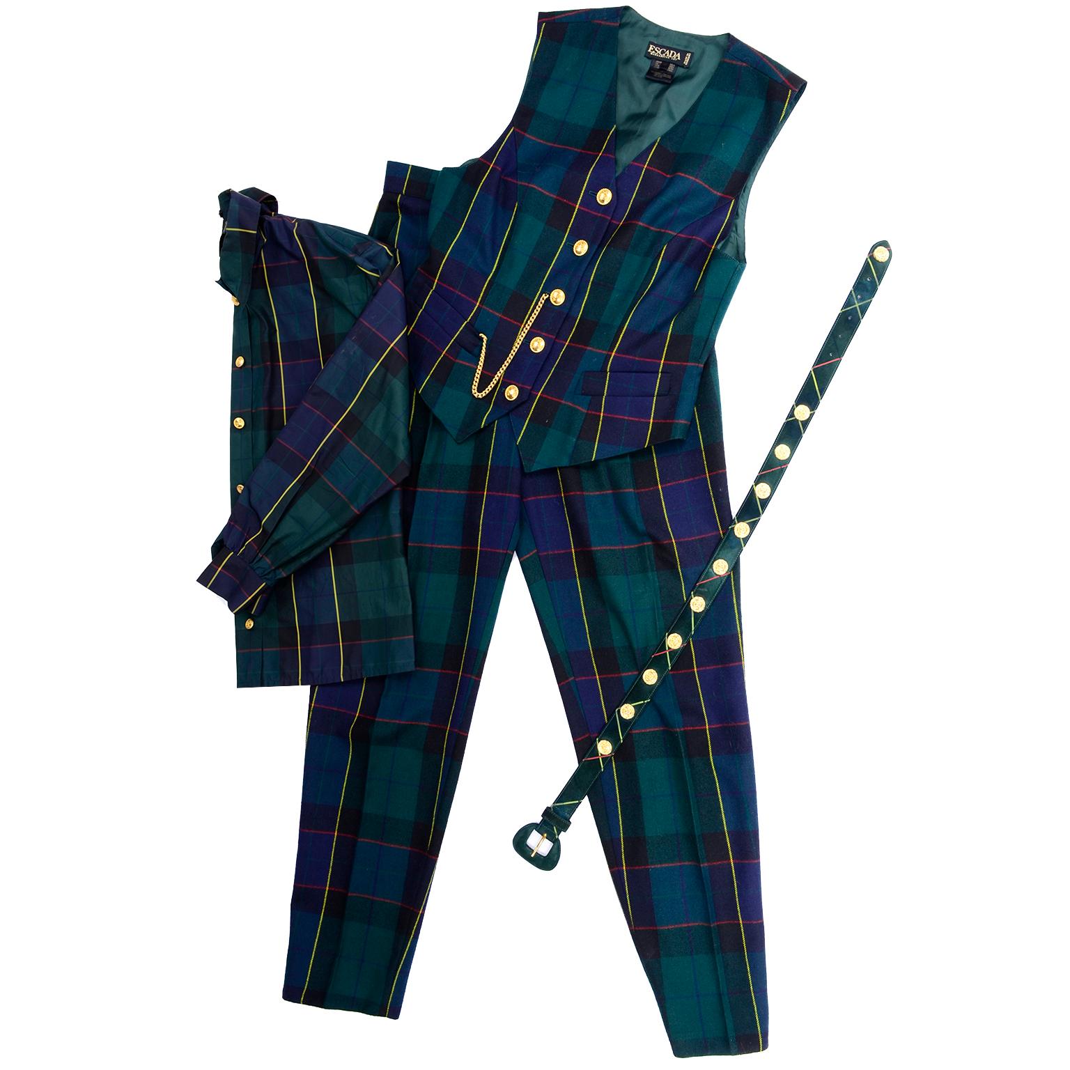 This is an incredible vintage green and blue tartan plaid pant suit from Escada designed by Margaretha Ley in the 1980's.  This ensemble includes a pair of high waisted trousers, a vest, a blouse with a tie, and a belt. 

There are gold rope buttons