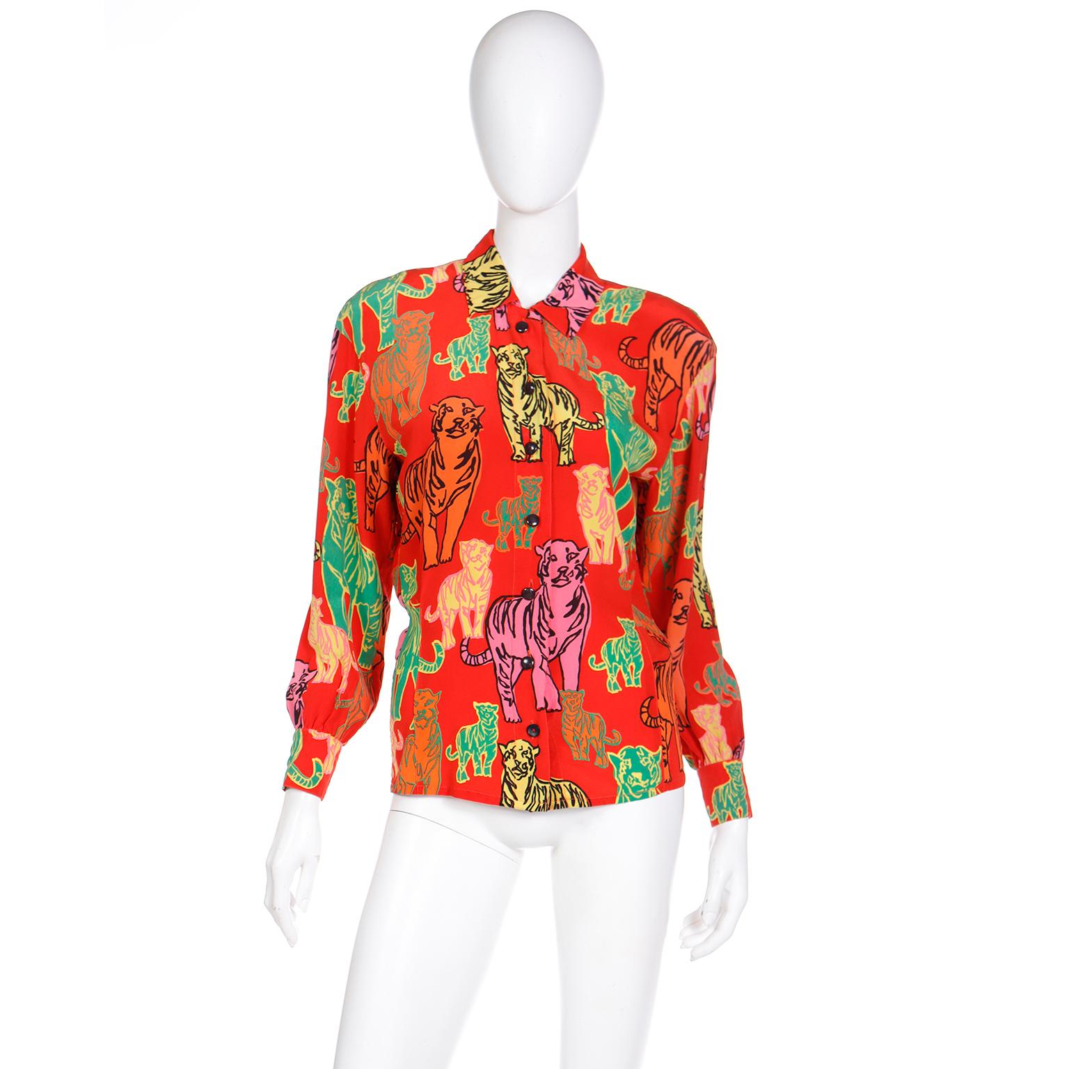 This is a fabulous vintage Escada Margaretha Ley novelty print red silk blouse that features tigers in bold shades of green, pink, yellow, and orange. The tigers are outlined in contrasting hues and we love the way they stand out against the red