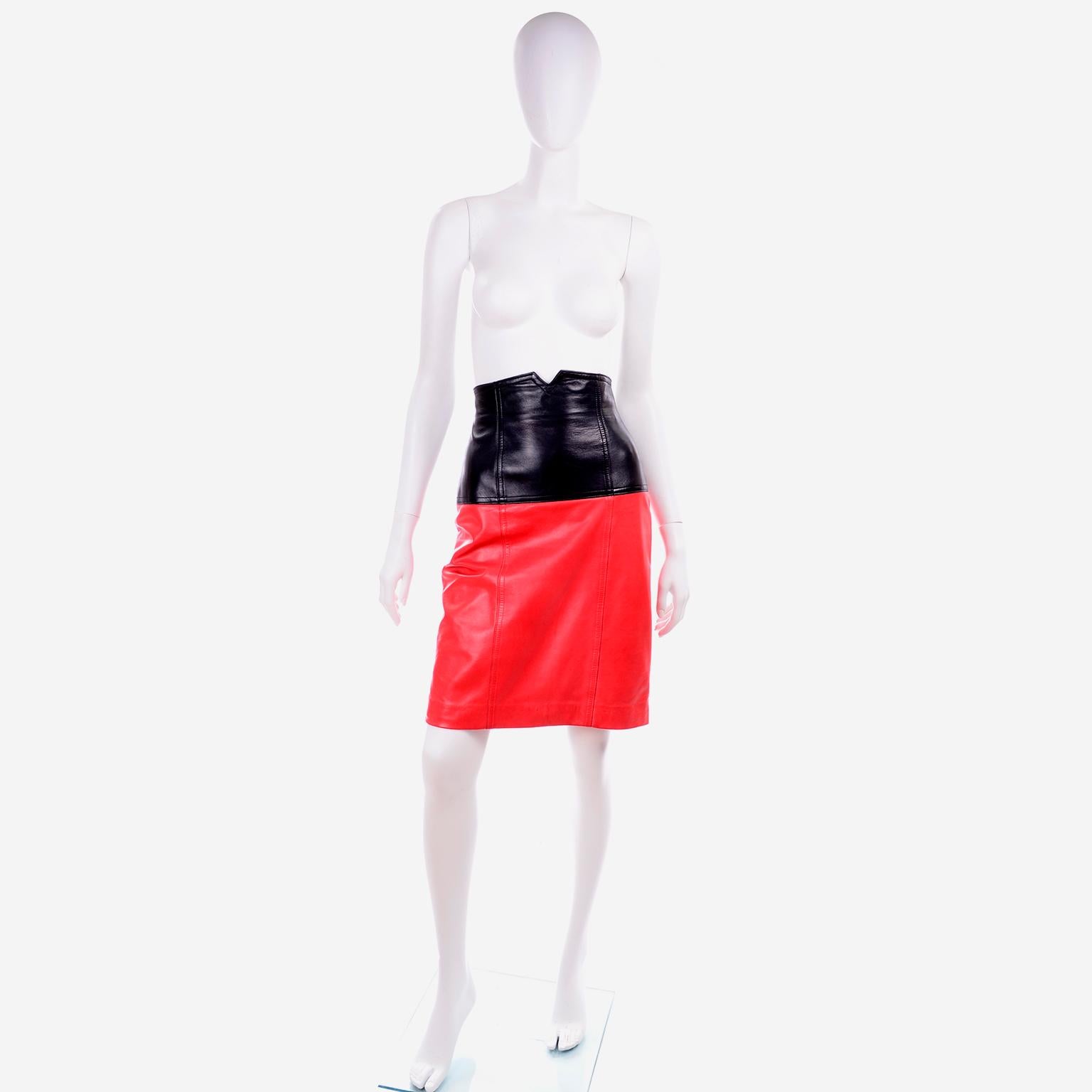This is an amazing bright red and black color block leather pencil skirt designed by Margaretha Ley for Escada. This 100% leather skirt is lined in red rayon and has a metal zipper down the center back seam for closure. We love the notch at the