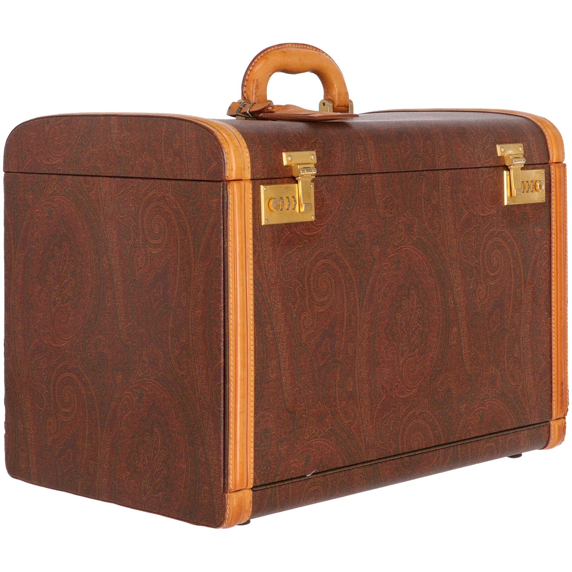 Timeless trunk by Etro in multicolor canvas with sophisticated baroque motif and brown caramel-tone real lather edges. It features a rigid leather single handle with luggage tag, two gold-tone metal combination locks on the front and four bag feet.