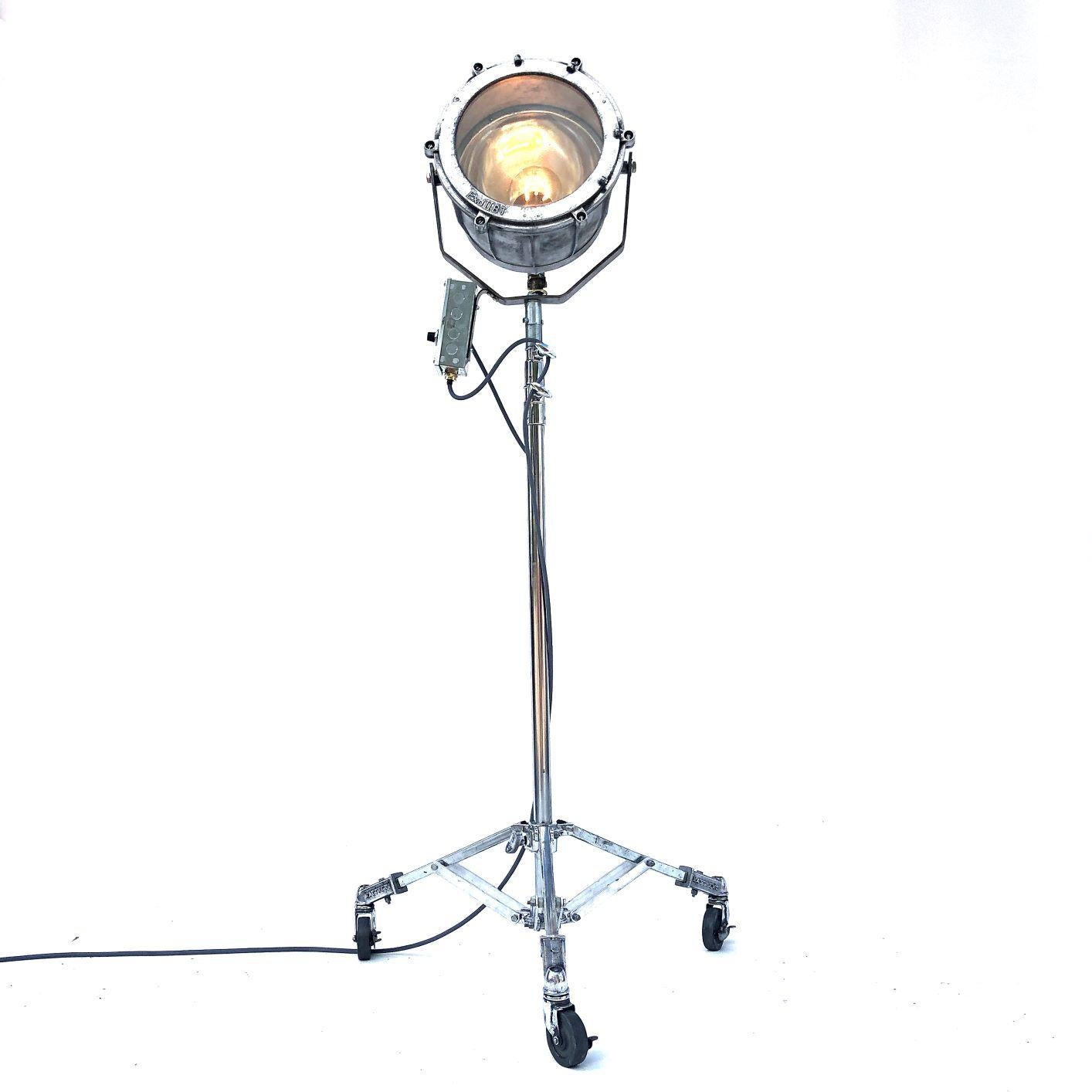 A reclaimed retro Industrial aluminum explosion proof cargo light coupled with a telescopic Matthews theatre Stand to create a bespoke floor standing lamp.

A dimmer switch has been added to the side of the fixture to operate the light. The light