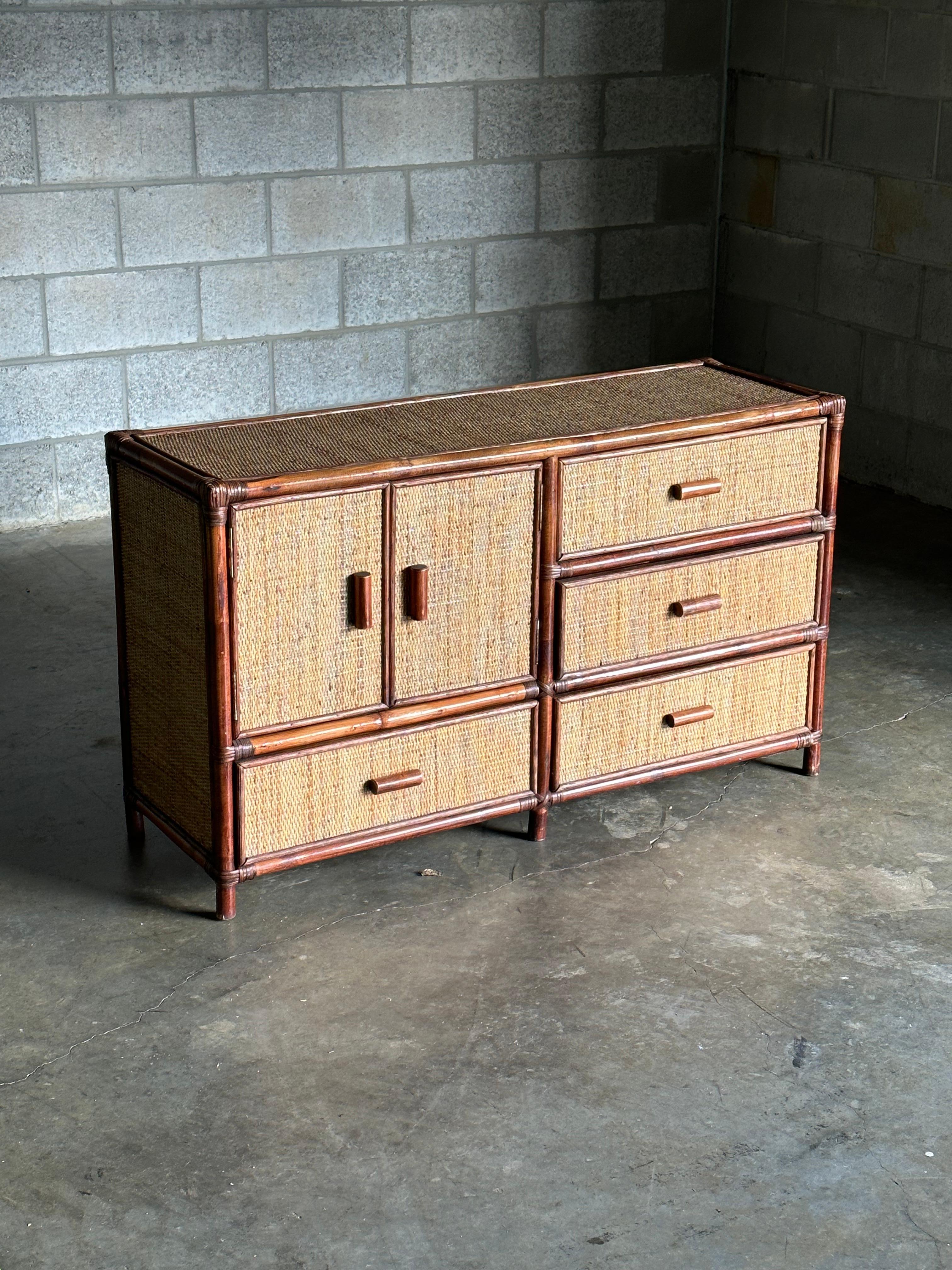 A gorgeous faux bamboo, cane, and wicker sideboard or dresser. Unique dimensions allow for a variety of uses such as tv strand, credenza, sideboard, or dresser.

The right side consists of three drawers, and the left side has a pair of doors with a