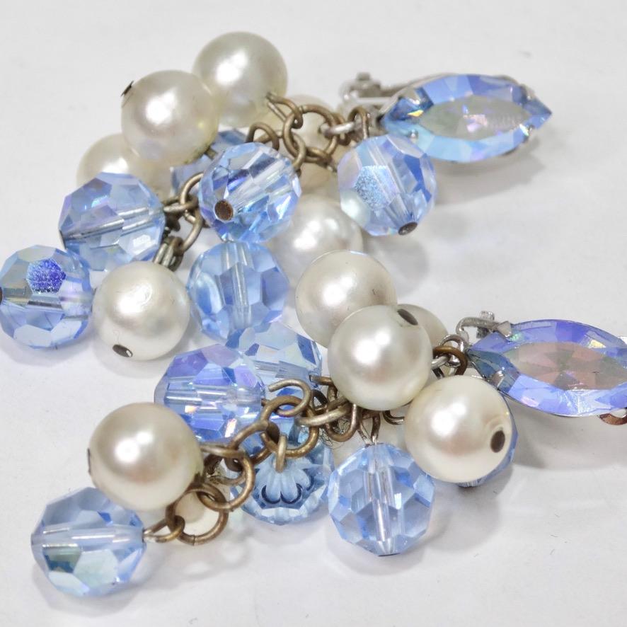 These 1980s blue rhinestone and faux pearl dangle earrings are begging to be added to your collection! Beautiful clip on earrings feature a plethora of faux pearls and light blue rhinestones to create these eye catching earrings. These earrings are