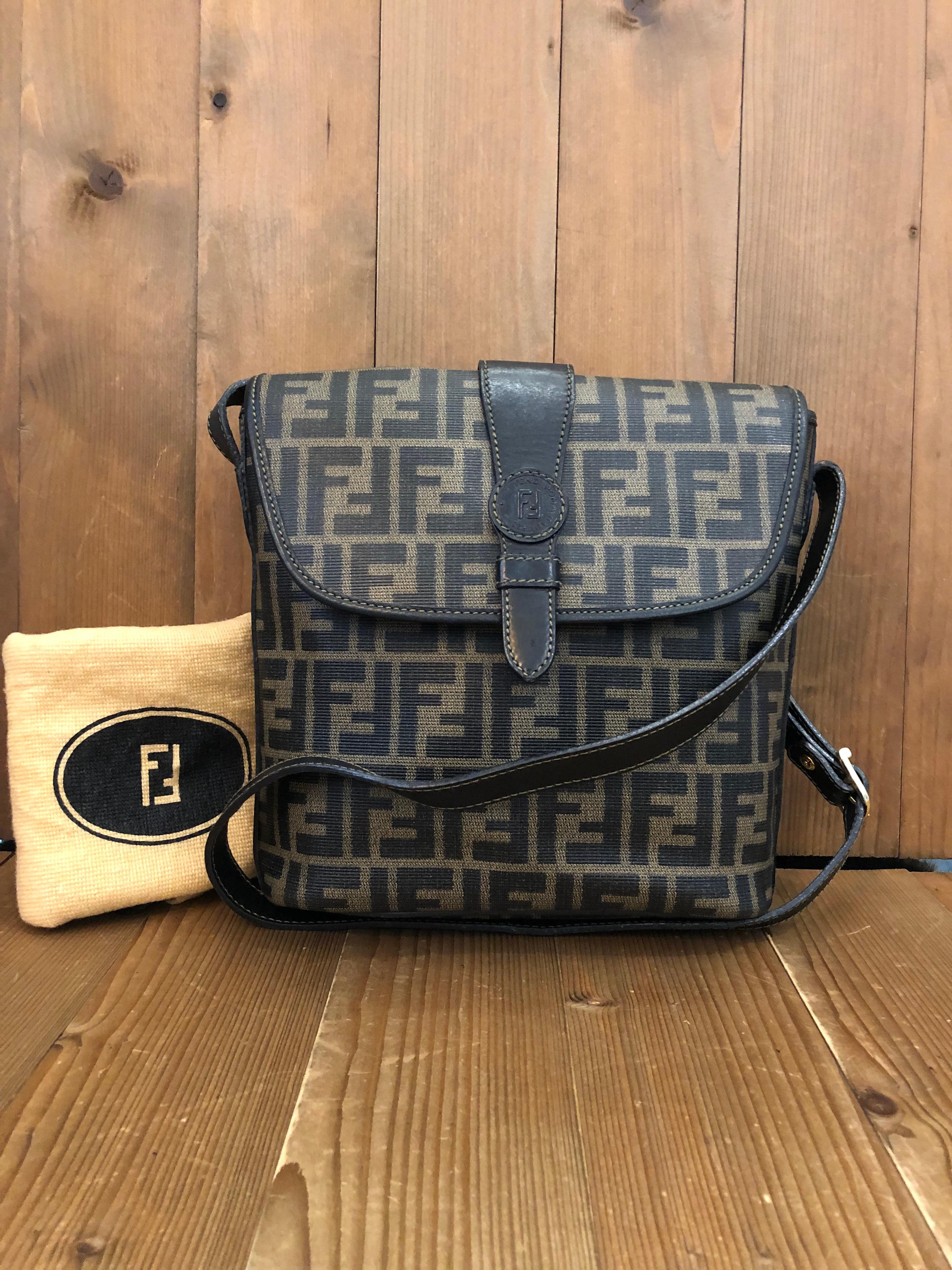 This is an exceptional vintage Fendi camera bag in Fendi’s iconic brown Zucca coated canvas and gold toned hardware. Front flap with magnetic snap closure. The messenger bag has a main spacious compartment with one interior zip pocket and one back