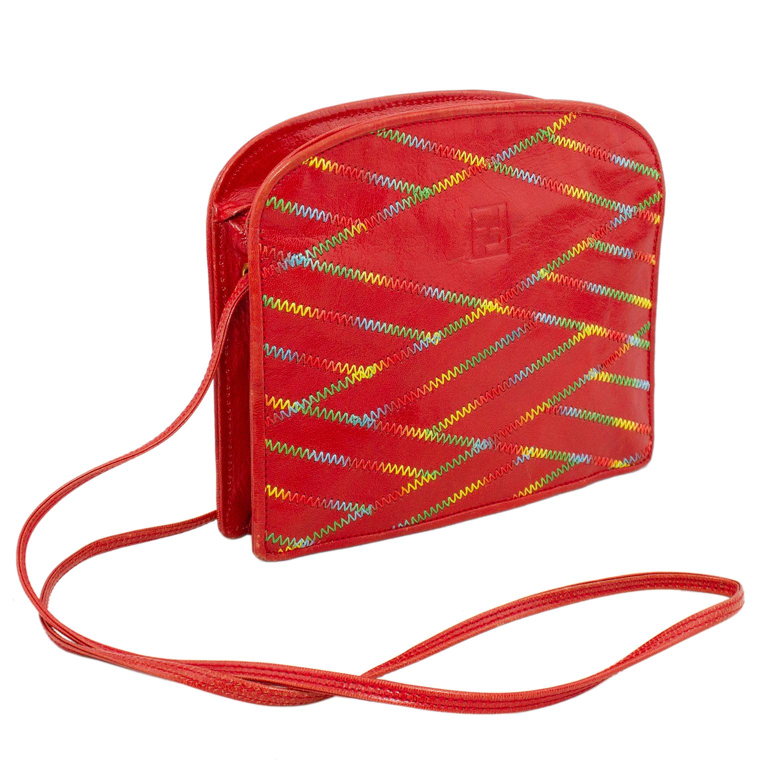 Fun & vibrant Fendi bag from the 1980s. Polished red leather with all over rainbow chevron top stitching. Top zipper opens to a brown Fendi logo lining with a single zippered slit pocket. Thin red leather strap can be used on the shoulder or cross