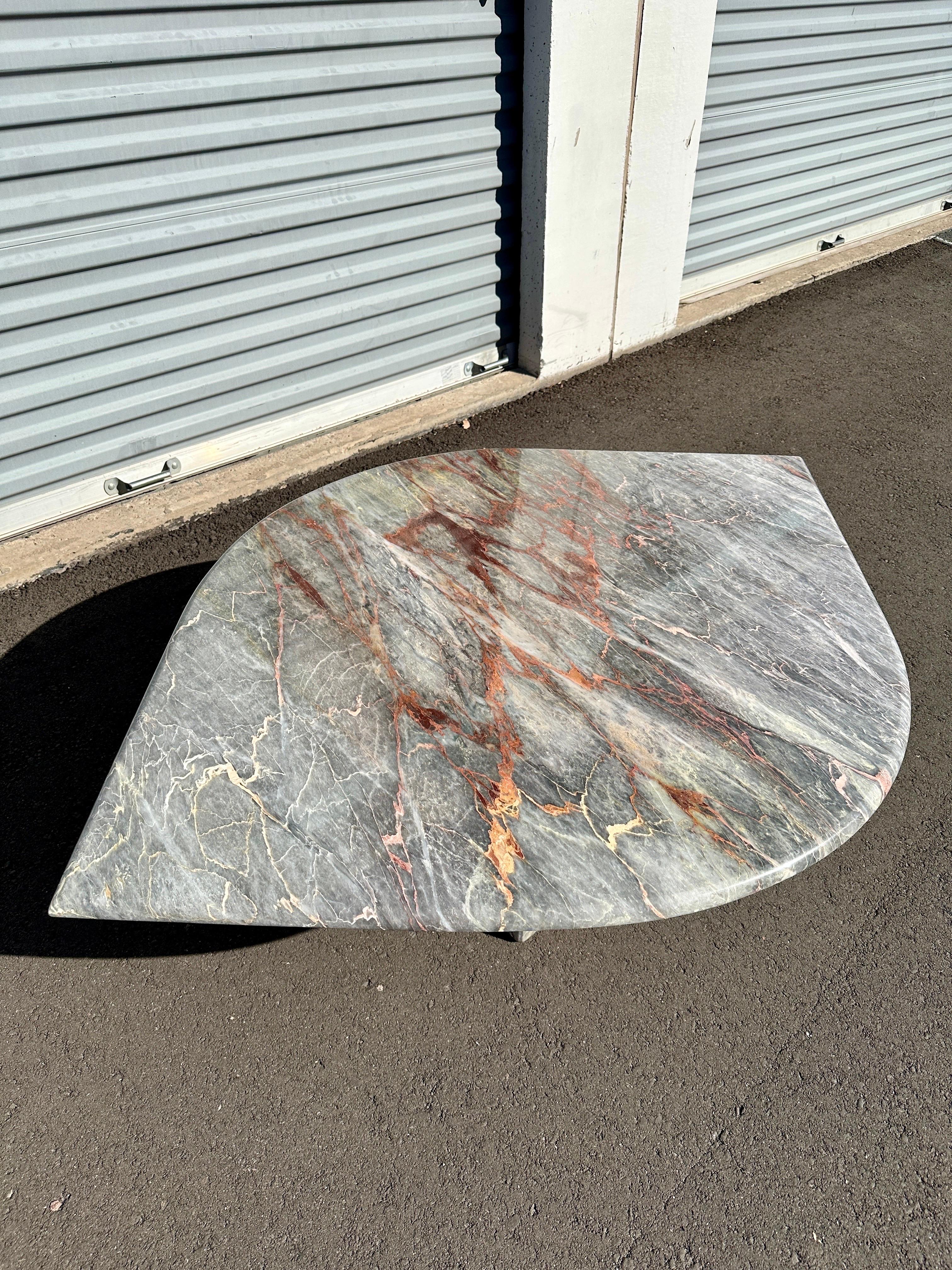 Sculptural and softly dramatic, this 1980s coffee table is crafted from Fior di Pesco marble—a prized Italian stone known for its painterly veining and ethereal palette. The table’s eye-shaped top floats above a hallow cubic base, creating a visual