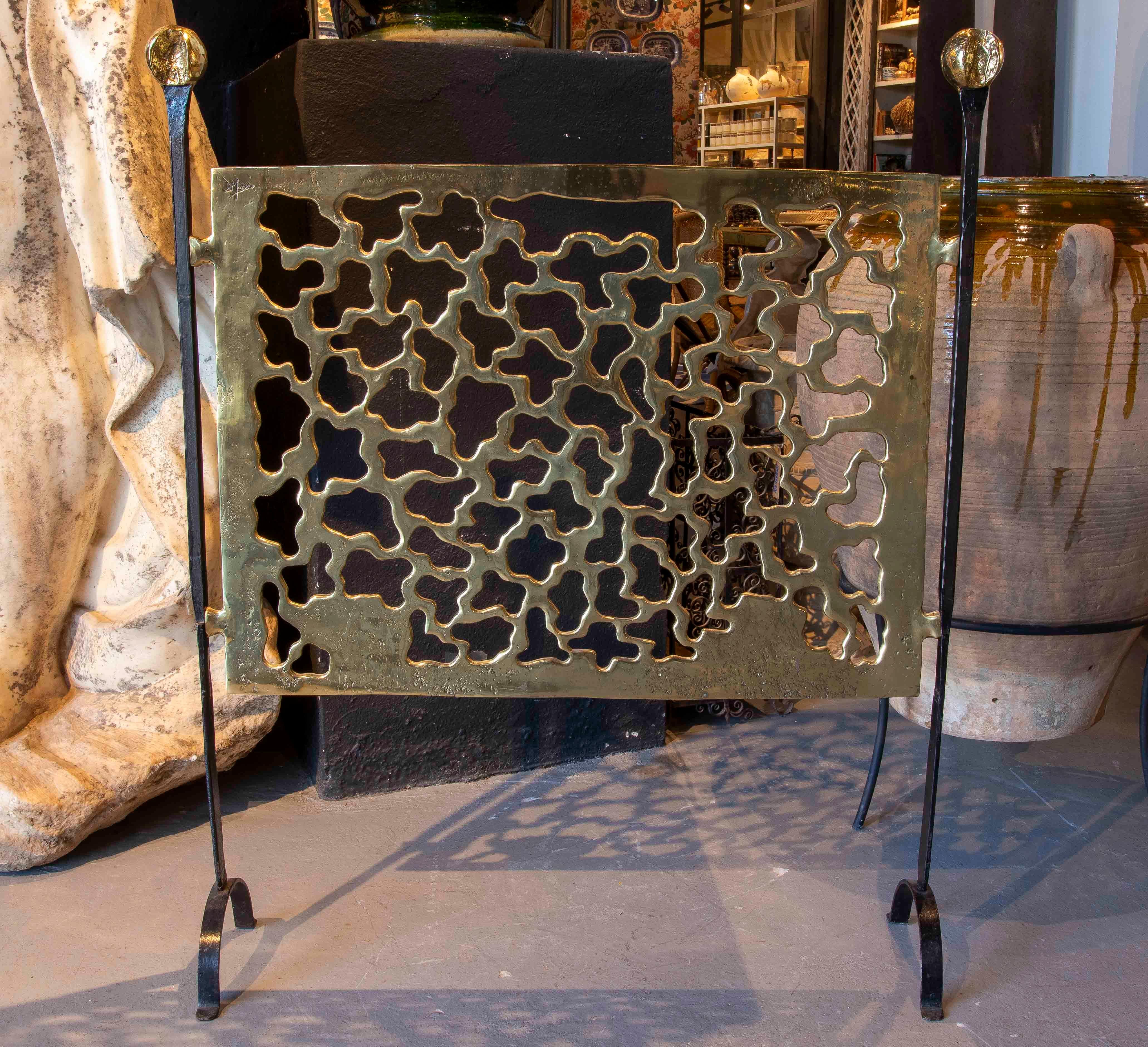 Attrape-étincelles pour cheminée conçu et signé par l'artiste et designer David Marshall. Réalisée en bronze massif poli, elle présente un panneau central ajouré aux formes organiques et abstraites, typiques du style sculptural de Marshall. Les