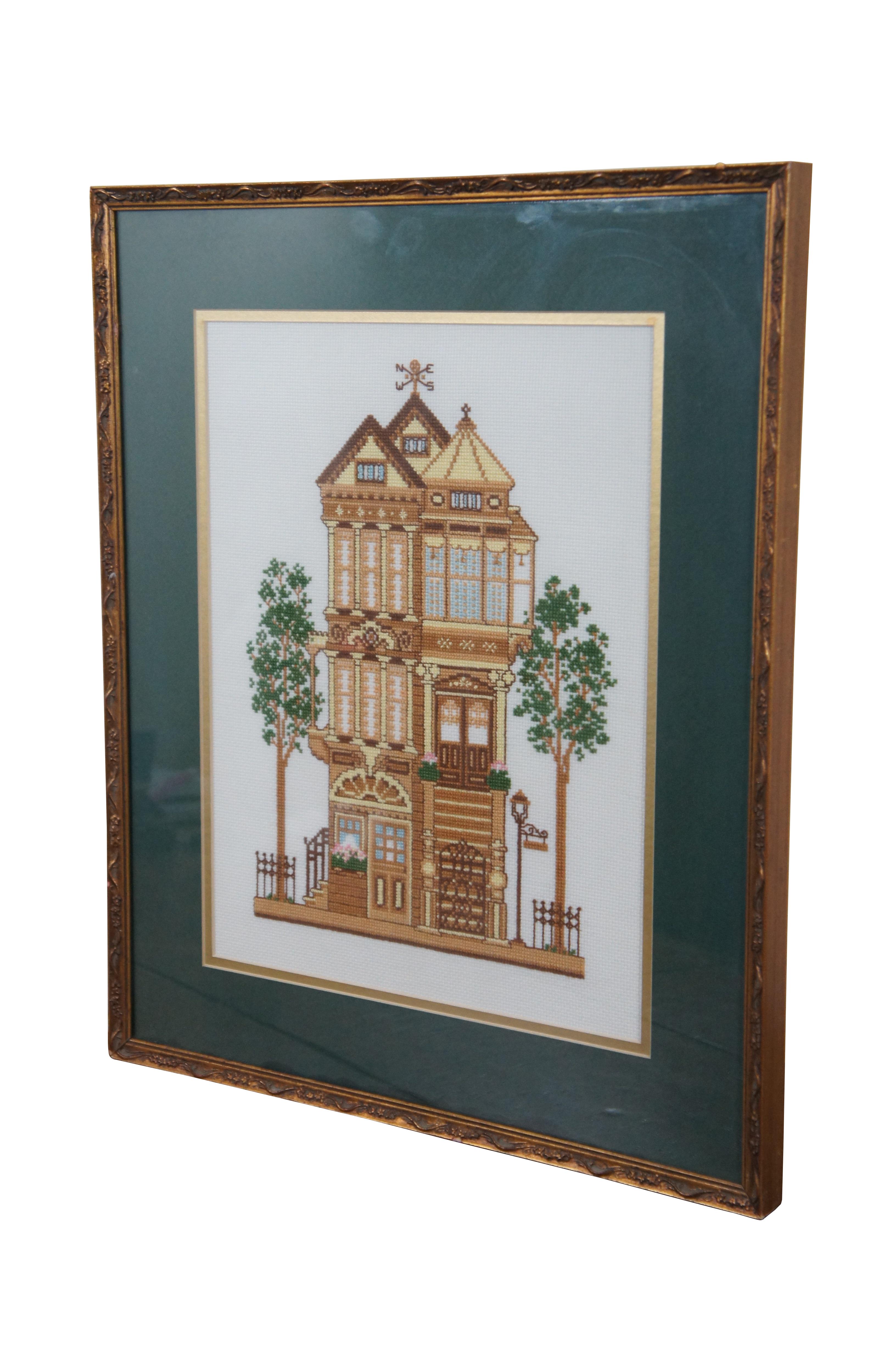 Framed piece of completed needlwork depicting a turn of the century yellow Victorian house, from the 1983 Sunset brand counted cross stitch kit #2945. Framed in a distressed gilded floral frame.

Dimensions:
16.75