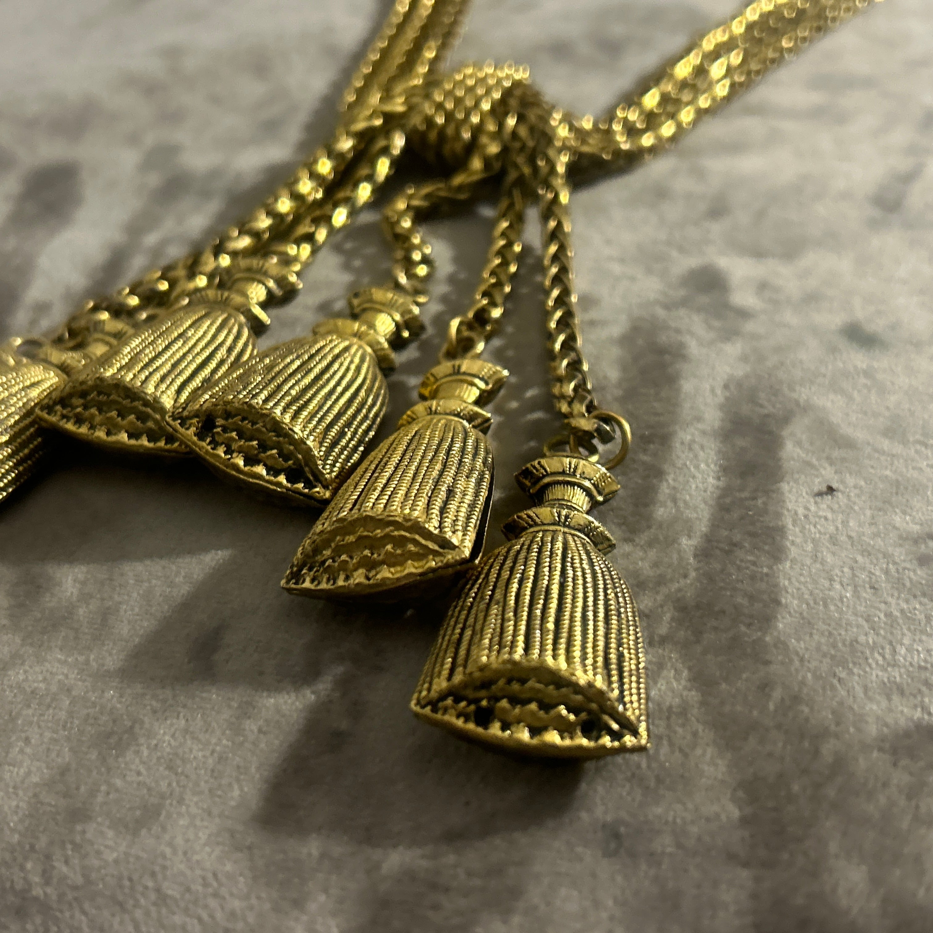 This vintage necklace, created by Franco Moschino in the 1980s, epitomizes the bold and playful elegance that characterized the designer's creations during this period. Made from gold-toned metal, the necklace features a striking knotted design at