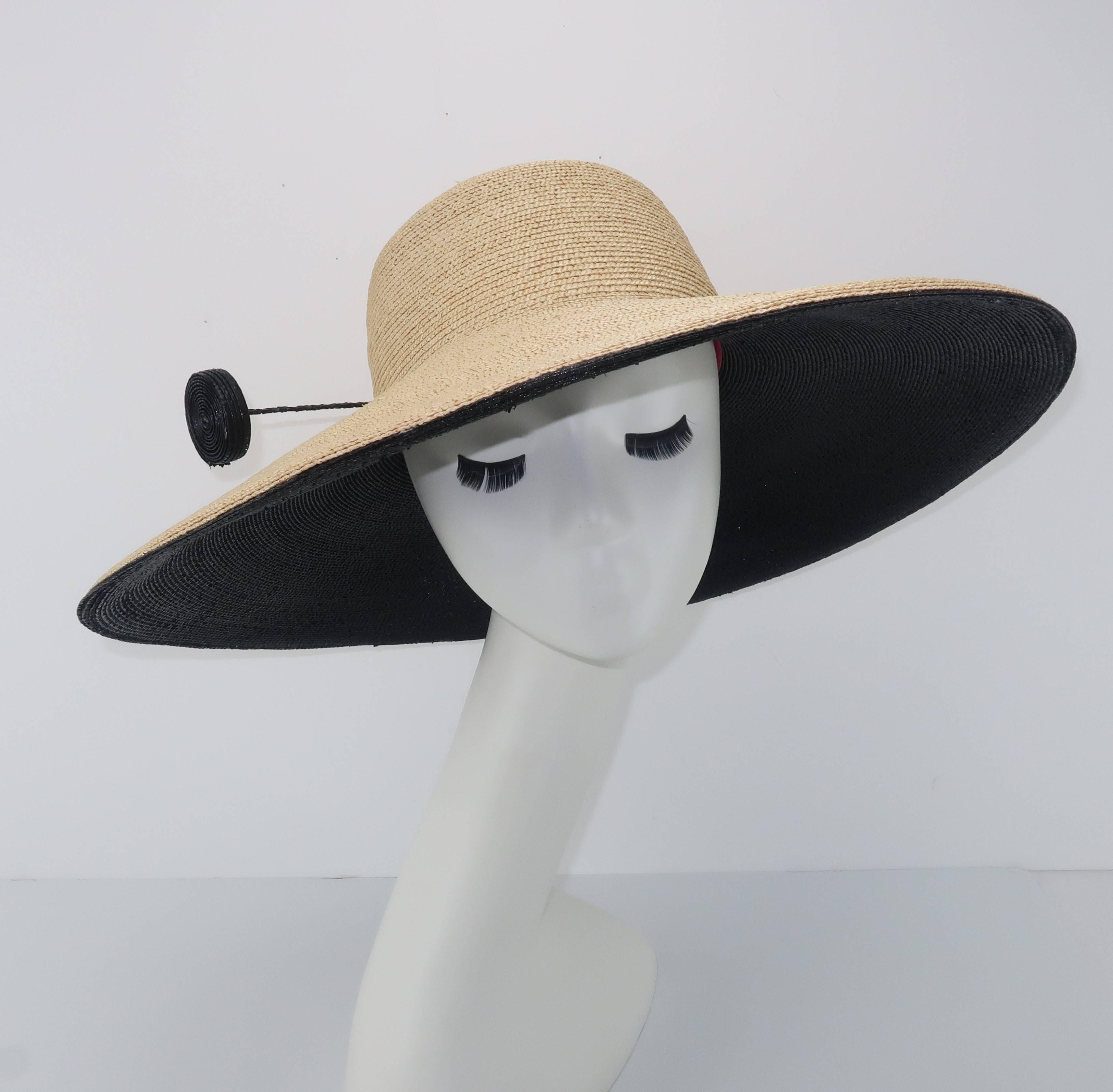 You may go incognito with this fabulously large brimmed hat by Frank Olive but you will never go unnoticed.  The ultra fashionable natural straw body of this hat is lined on the inner brim with a layer of contrasting black straw.  The graphic color