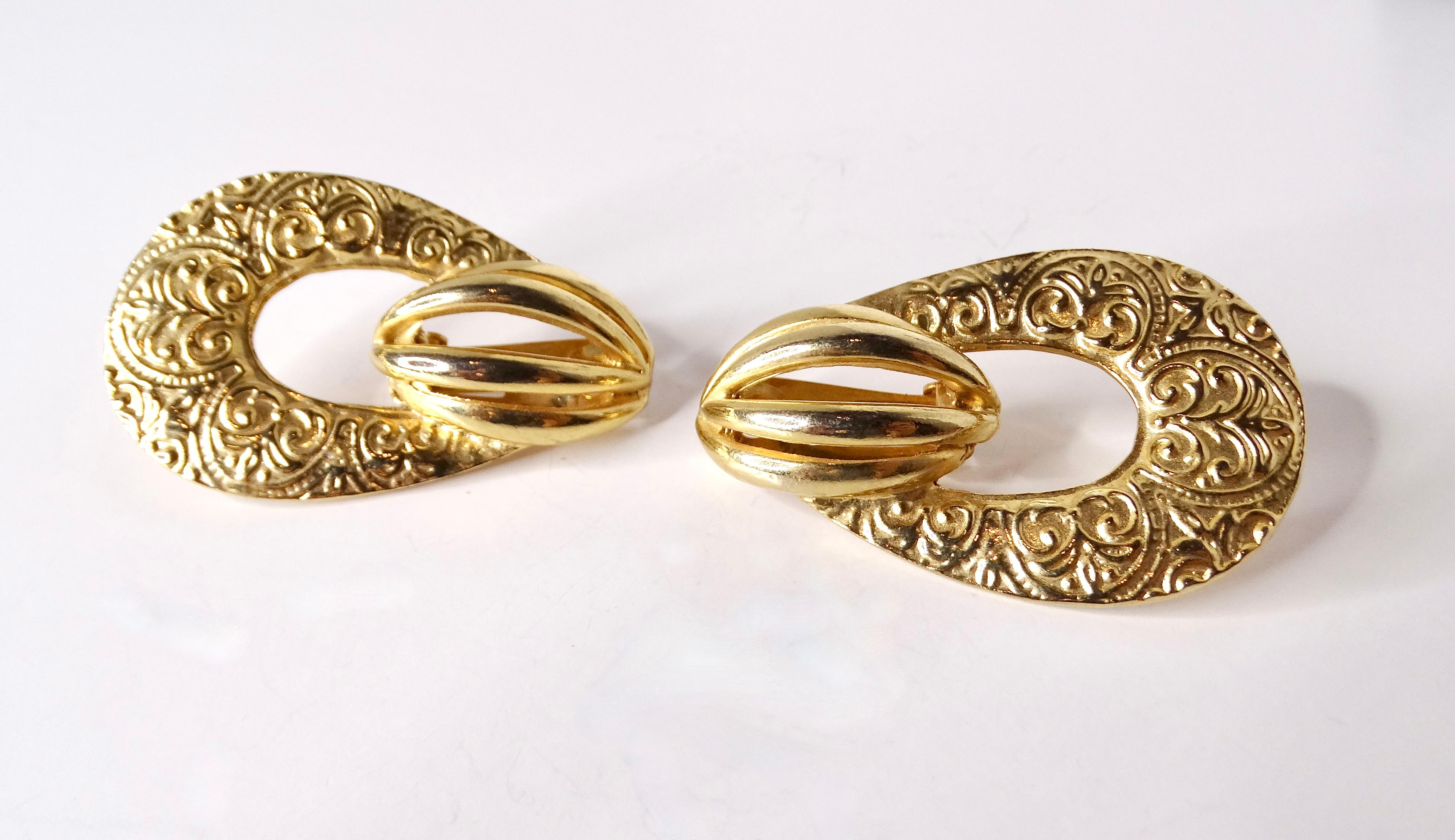 Step back into the elegance of the 1980s with these exquisite French detailed 14k yellow gold plated door knocker earrings. Anchored in the luxurious design sensibilities of the era, these stunning earrings capture the playful opulence and textured