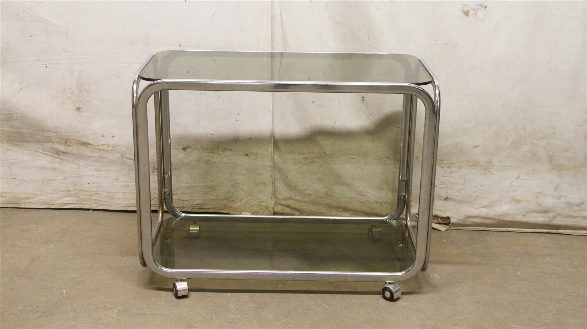 1980s bar cart with a chrome frame and dark glass shelves from France done in a Mid-Century Modern style. This can be seen at our 333 West 52nd St location in the Theater District West of Manhattan.
