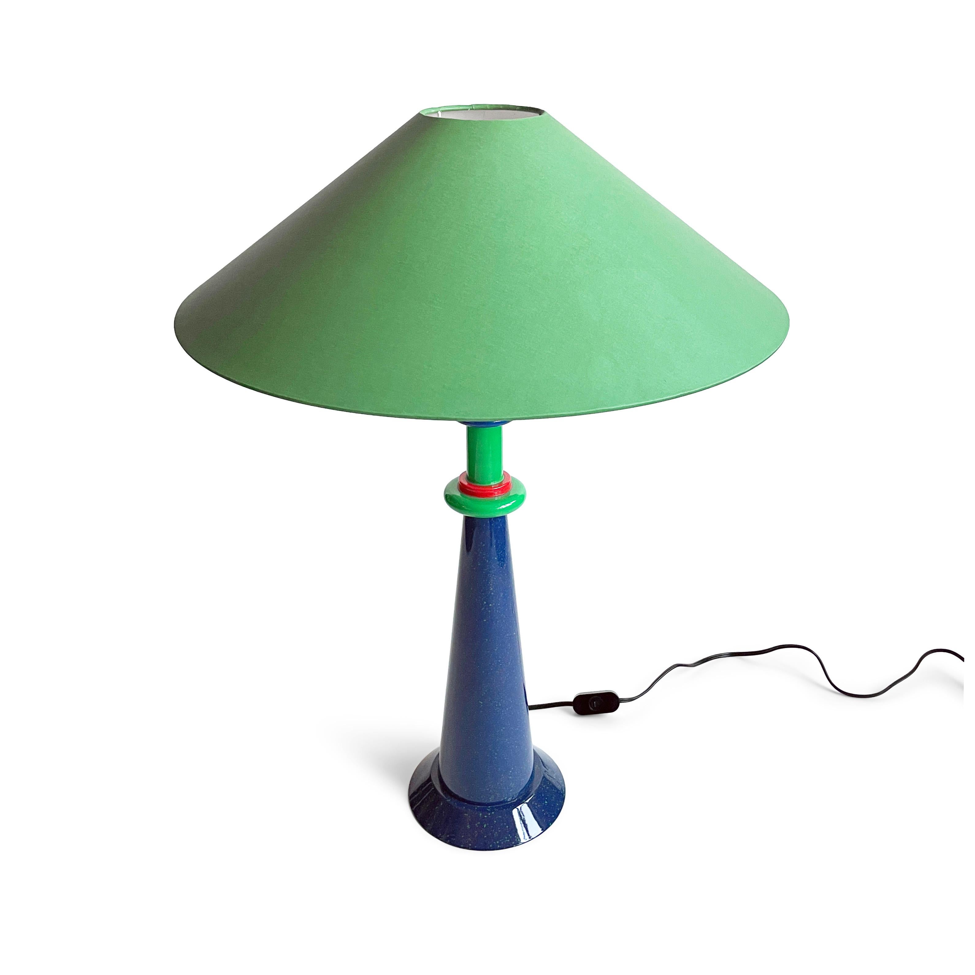A stunning 1980s French postmodern table lamp designed by Olivier Villatte. Drawing on a strong Memphis Milano inspiration, Villatte designed a high gloss lacquered wood lamp with a speckled blue body and red and green accents that is sophisticated