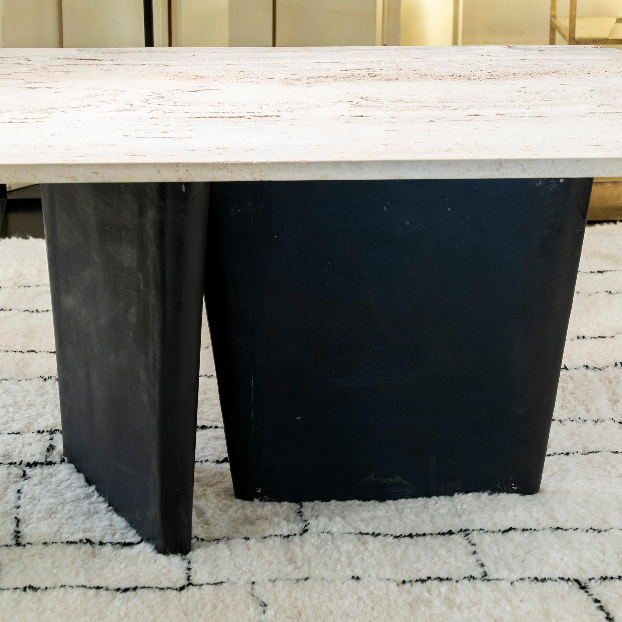 French table realized with a travertine slate attached to a raw steel sheet with three asymmetrical legs, the natural travertine top has peculiar characteristics such as holes and cuts that give the piece a strong and raw look but at the same time