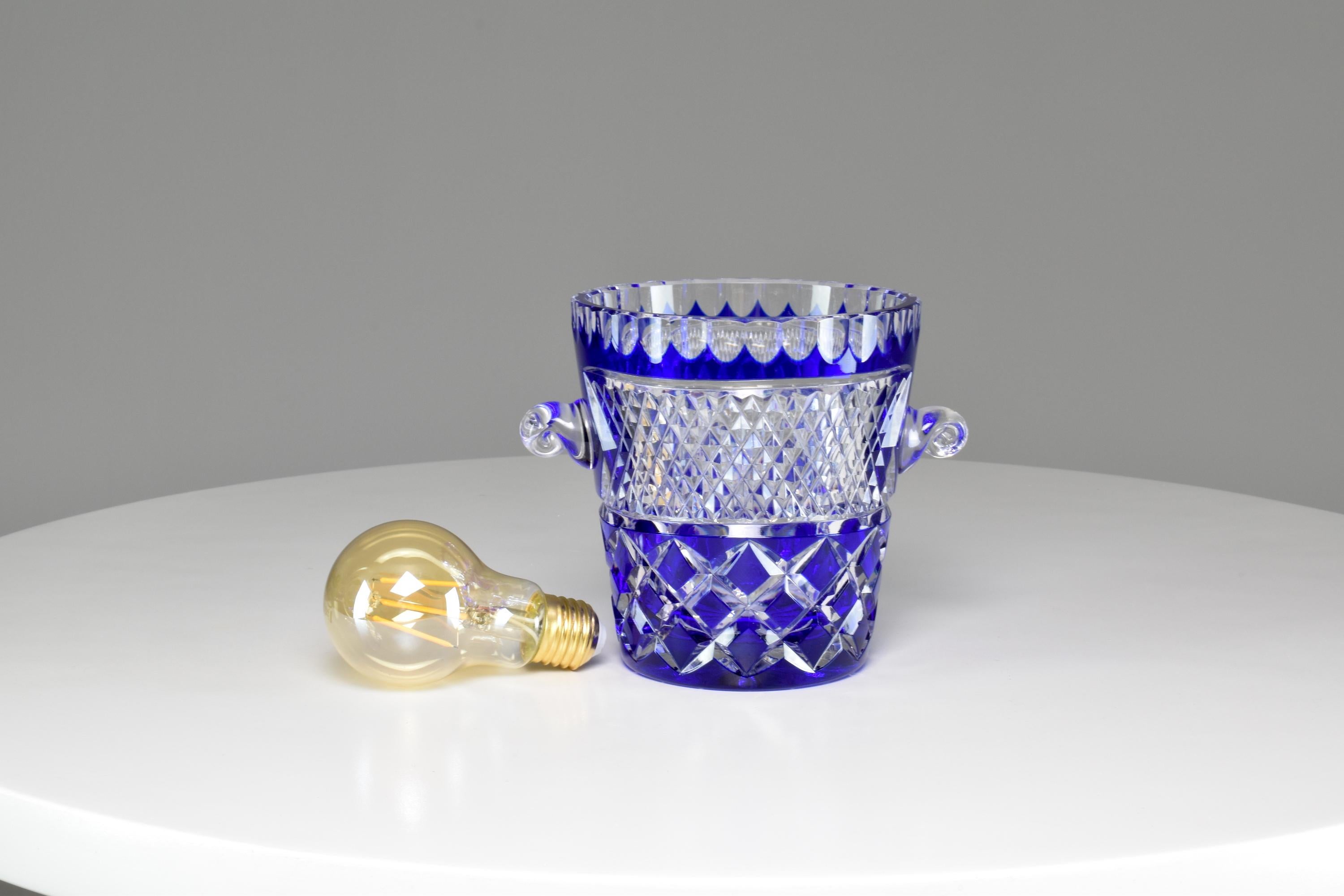 Superbe seau à glace ou à champagne bleu foncé de la fin du 20ème siècle par Crystal de Bohême. Cette pièce en cristal taillé est accompagnée d'une cuillère à glaçons et est brillamment sculptée à la main. 
-------

Nous sommes un espace