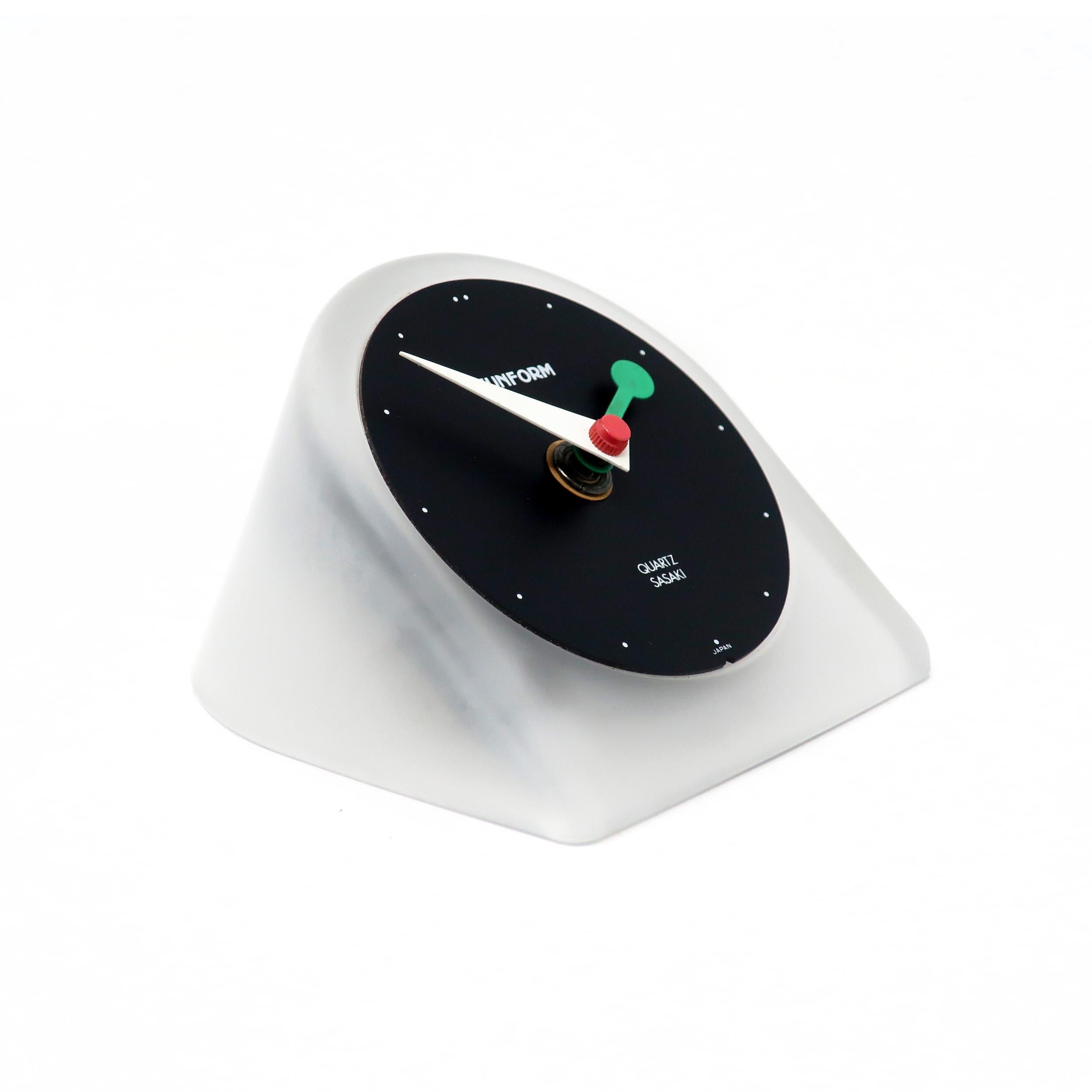 A handsome postmodern desk clock by Sunform, a sub-brand of Sasaki, the Japanese consumer products manufacturer. Made of frosted glass with black face, green and white hands, and red accents. The perfect simplicity of 1980s design.

In good