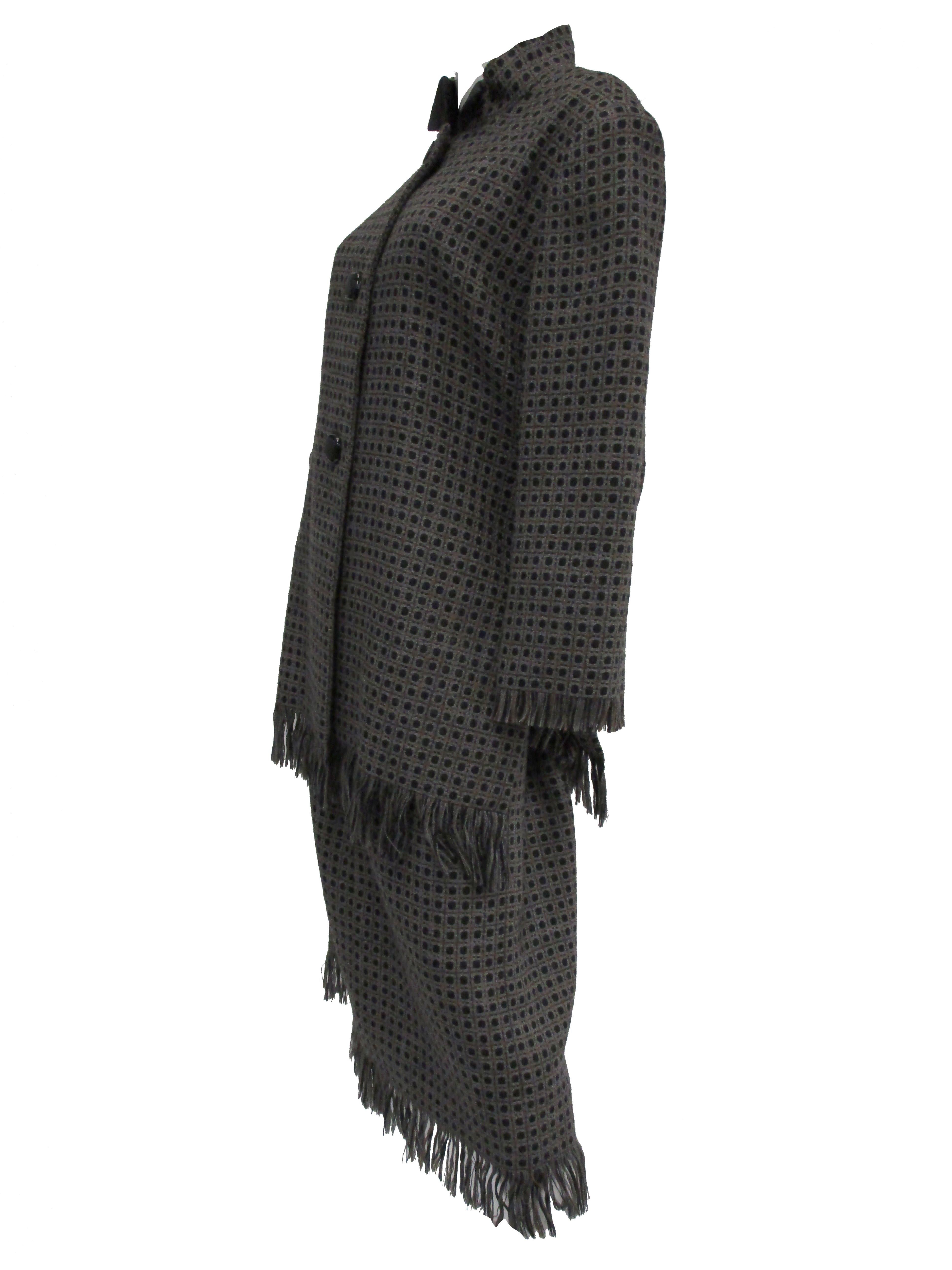 Fabulous heavy wool skirt suit by Galanos! The knee length skirt has a loose A - line silhouette with fabulous long fringes at the hem. The jacket has a loose and boxy fit, with straight and structured shoulders, a mandarin collar with wing tips,