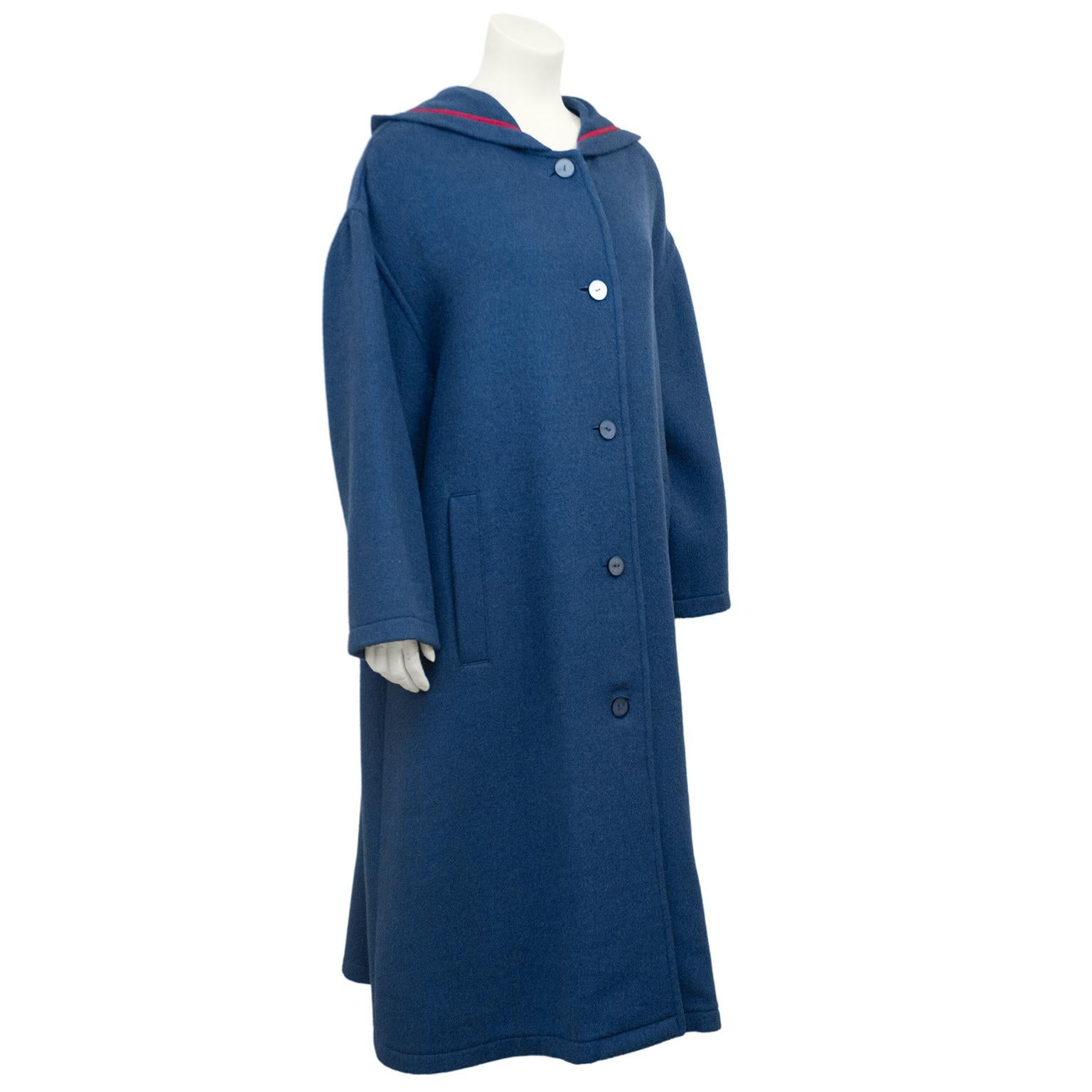 1980s Geoffrey Beene teal blue felted wool coat with rose pink trim. Dropped shoulder with slight dolman shaped sleeves and hood. Large single inverted pleat at centre back. Vertical slit pockets and matching blue plastic buttons. Unlined. Oversized