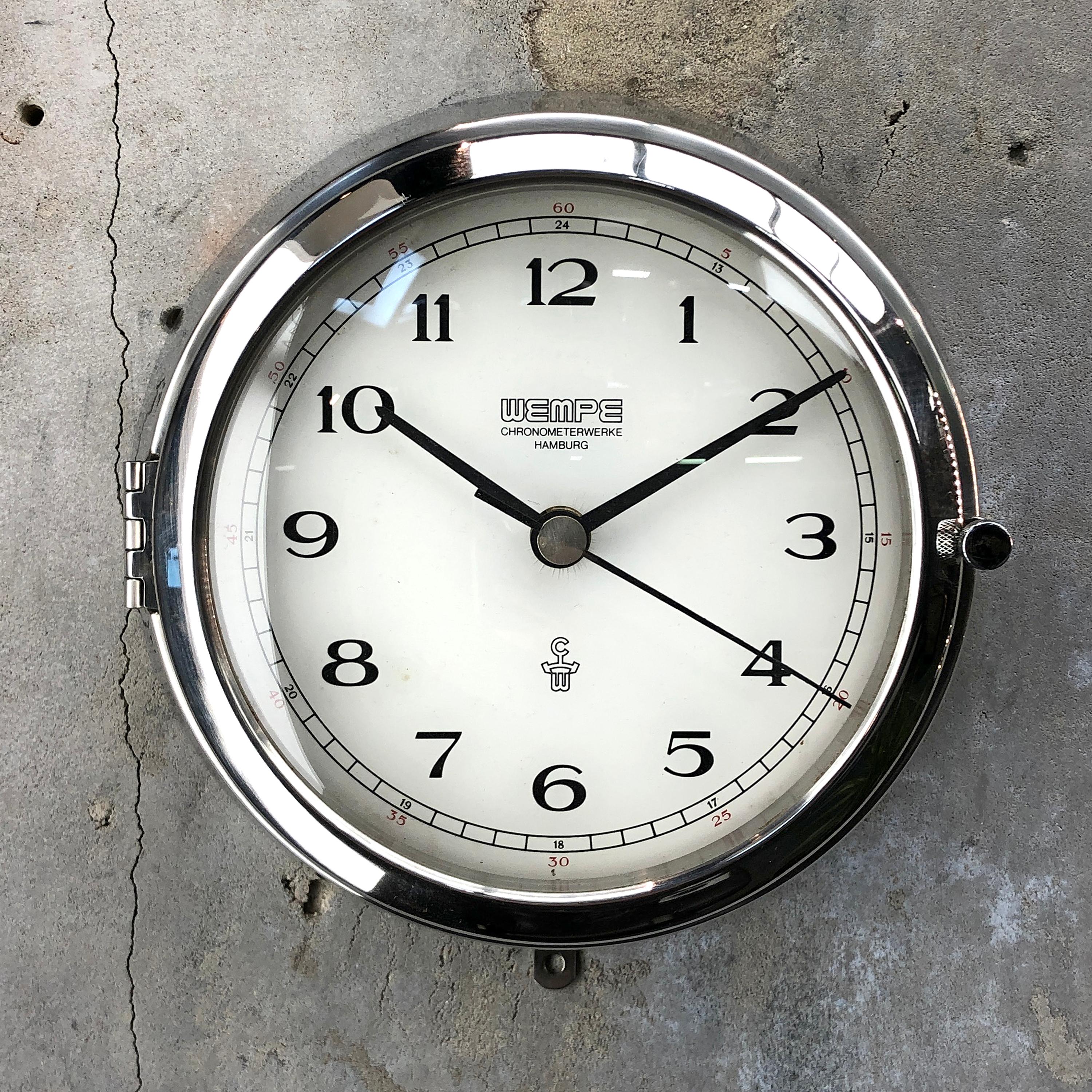 Chronometer wall clock by Wempe of Oldenburg, Germany.

Chromed brass case with convex glass to reduce glare.

Fully refurbished, in fine working condition and featuring a chronometer quartz movement.

The battery powering the movement is an