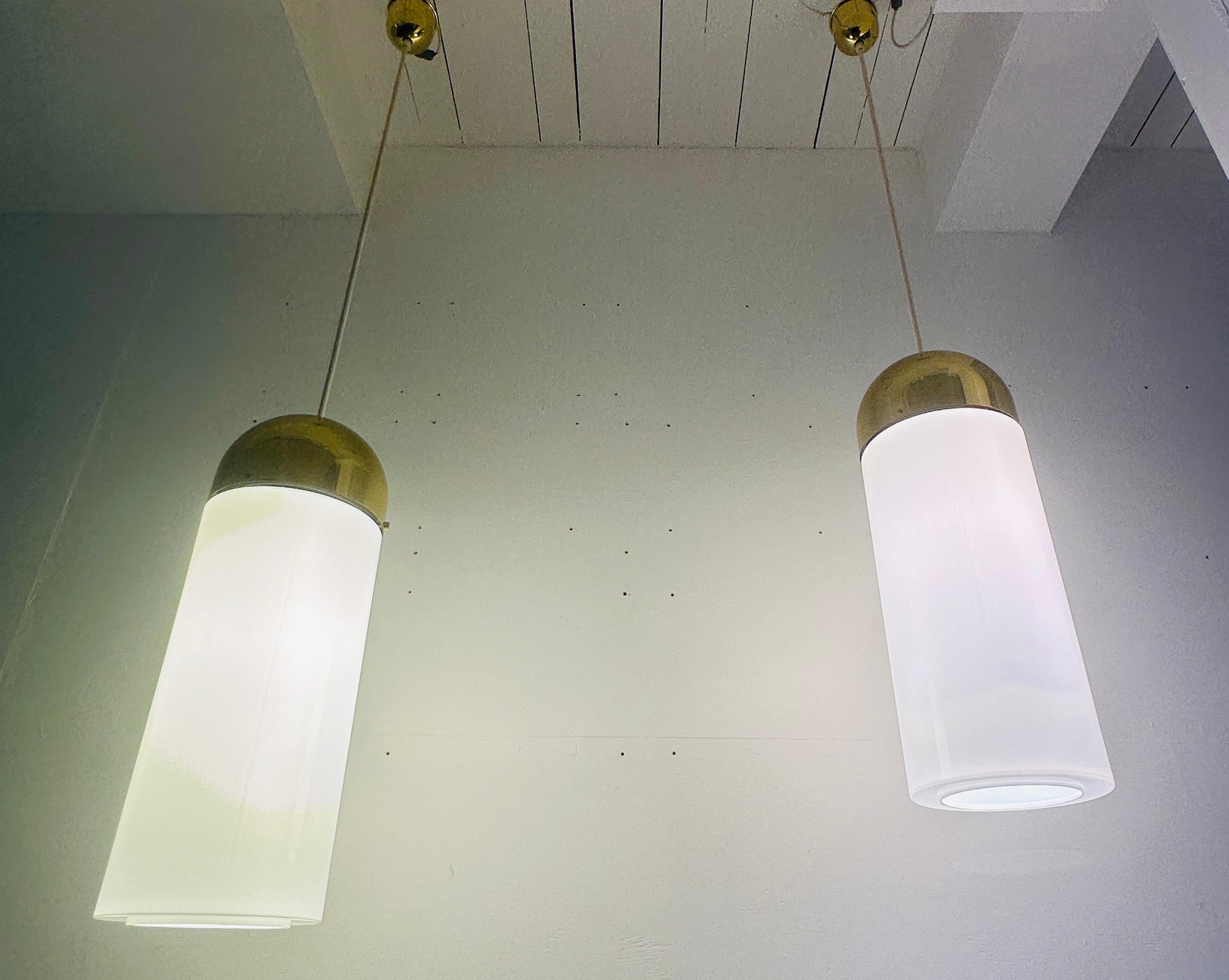 1980er Jahre deutsche große opalisierende weiße und polierte Messing gewölbte zylindrische Pendelleuchte hergestellt von Glashütte Limburg. Diese elegante, industriell anmutende Lampe ist sehr groß und schwer.  Der weiße Glasschirm wird mit einer