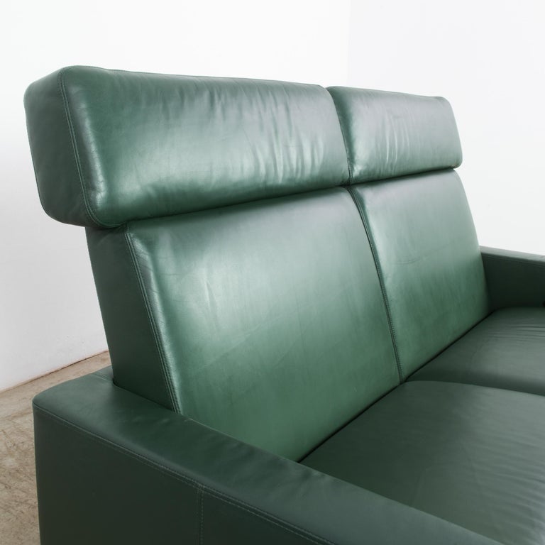 This pine green two-seater leather sofa was made in Germany, circa 1980. It was manufactured by Brühl, acclaimed for their sustainable and versatile seating concepts. This versatility is evident in the adjustable heights of the backs and the