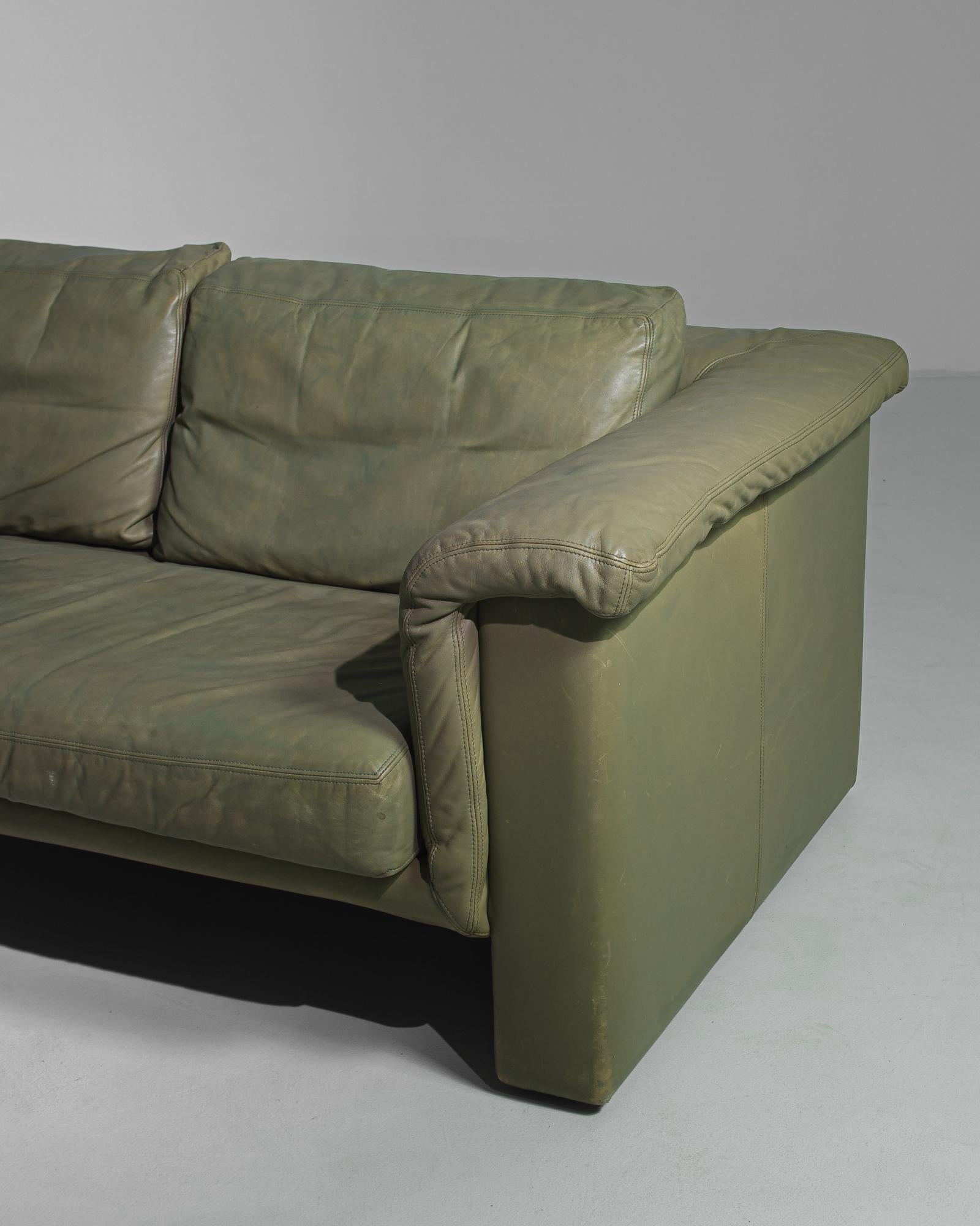 This durable leather sofa with a subdued olive green tone was made in Germany, circa 1980. Large proportions, deep seats, and wide sloped armrests ensure superior comfort. Designed and fabricated by Knoll, a furniture maker celebrated for their