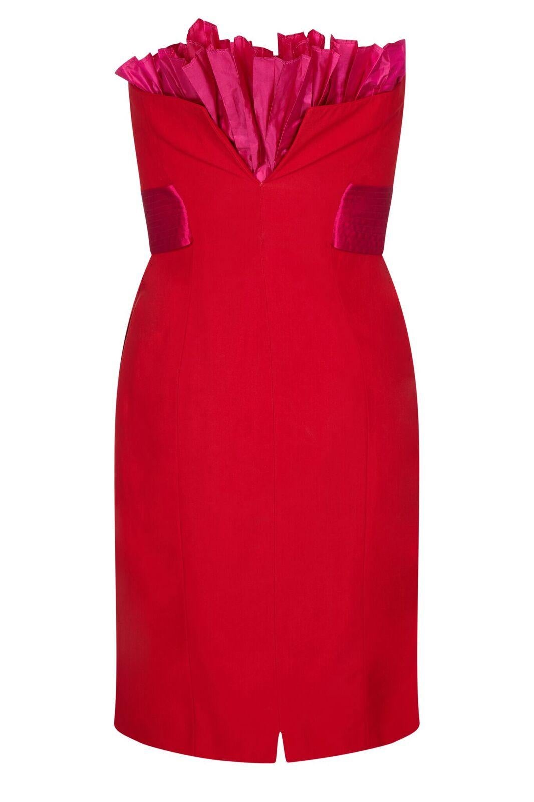 This arresting 1980s crimson silk cocktail dress by Gianfranco Ferre is of excellent quality and features a show-stopping design. The piece combines stylish simplicity with flamboyant, innovative tailoring. At first glance we see a knee length