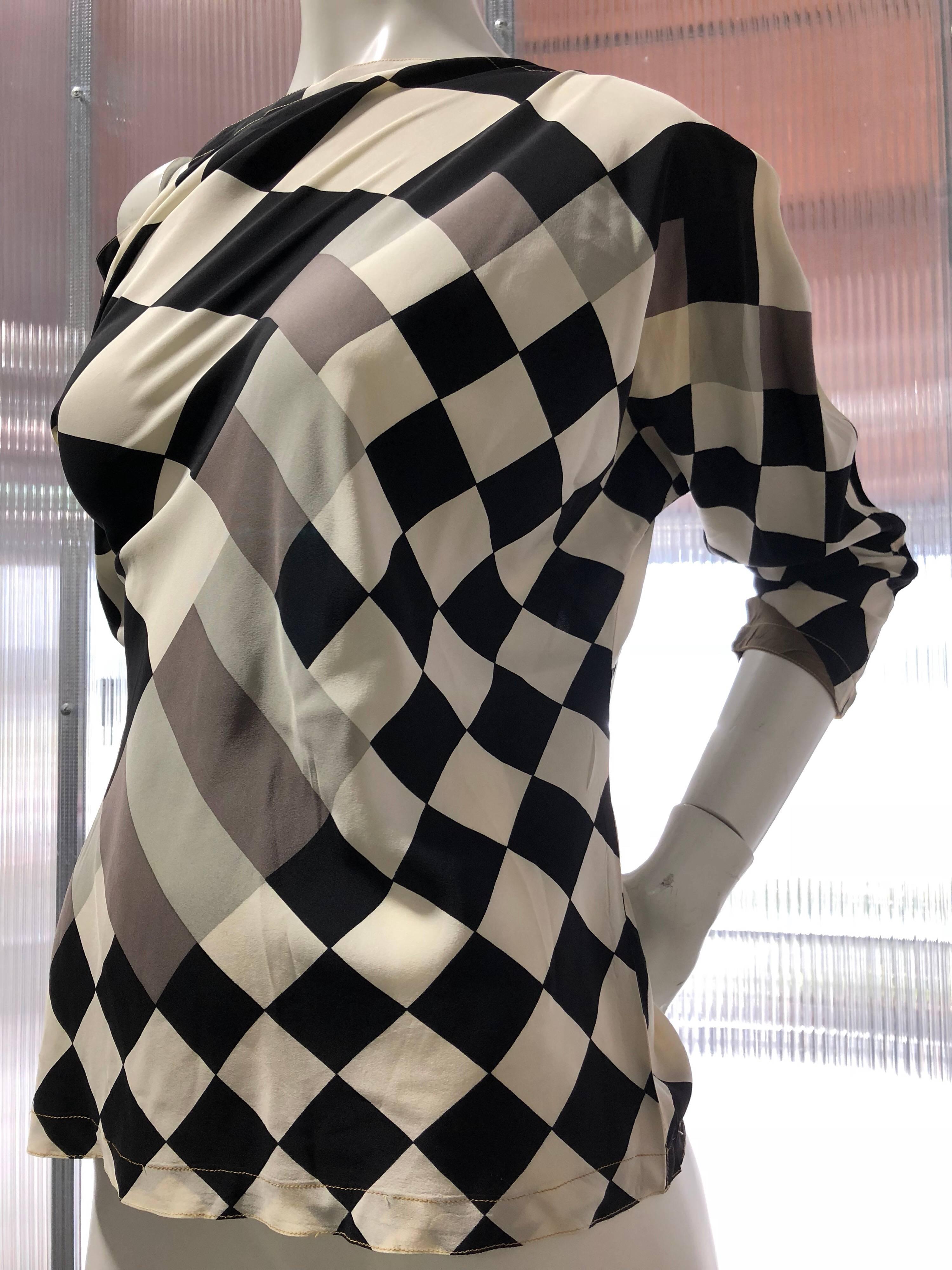 1980s Gianni Versace black and white checkered off-the-shoulder long-sleeved silk blouse with pixilated pattern.  Slips over the head with tapered-to-cuff Dolman sleeves. Uber-sexy 1980s! Size 42