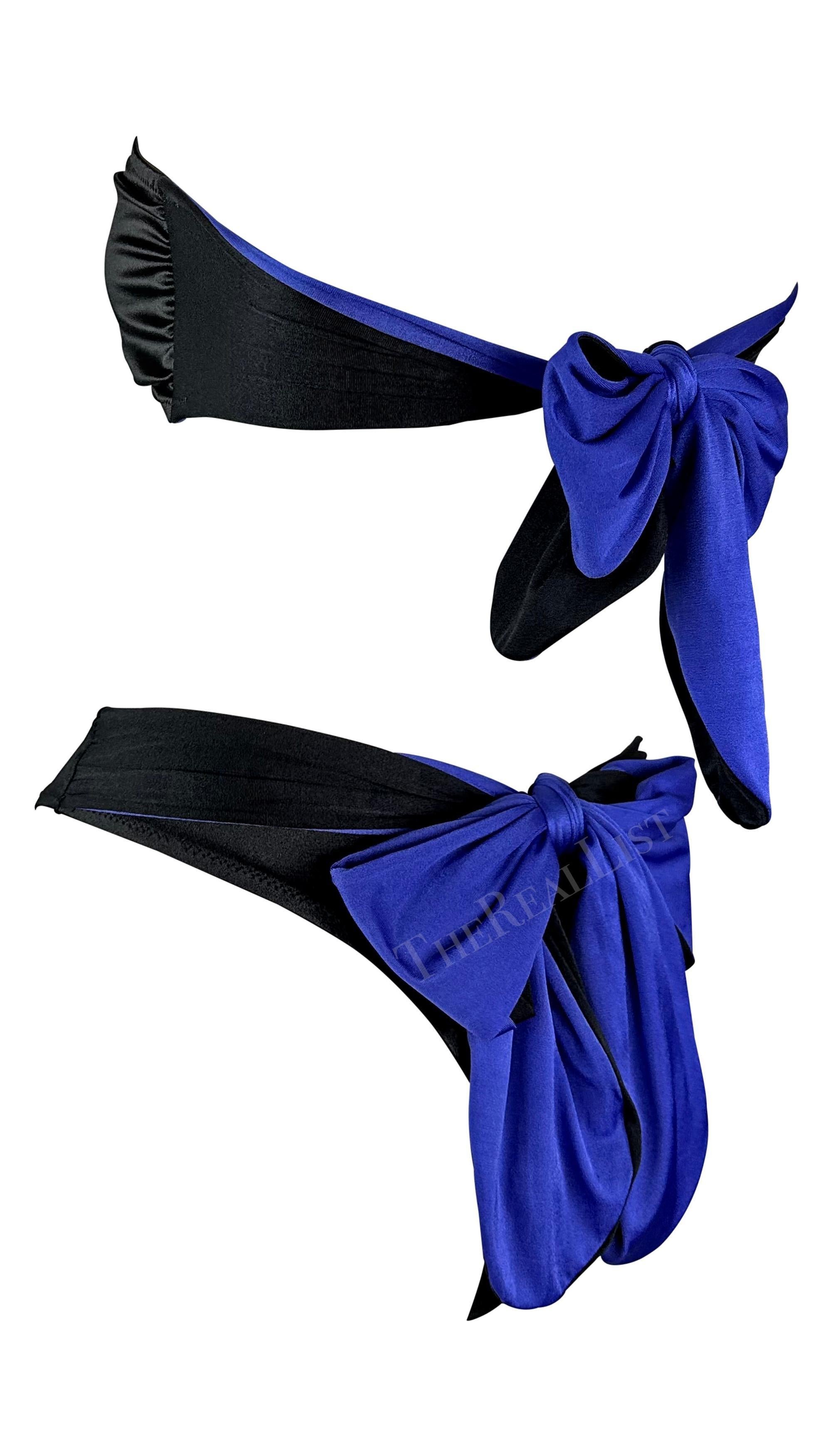 Nous vous présentons un bikini bustier chic noir et violet, conçu par Gianni Versace. Datant des années 1980, ce bikini horloge bicolore présente une taille haute et un nœud papillon violet juste au-dessus des fesses. Un anneau violet entre les