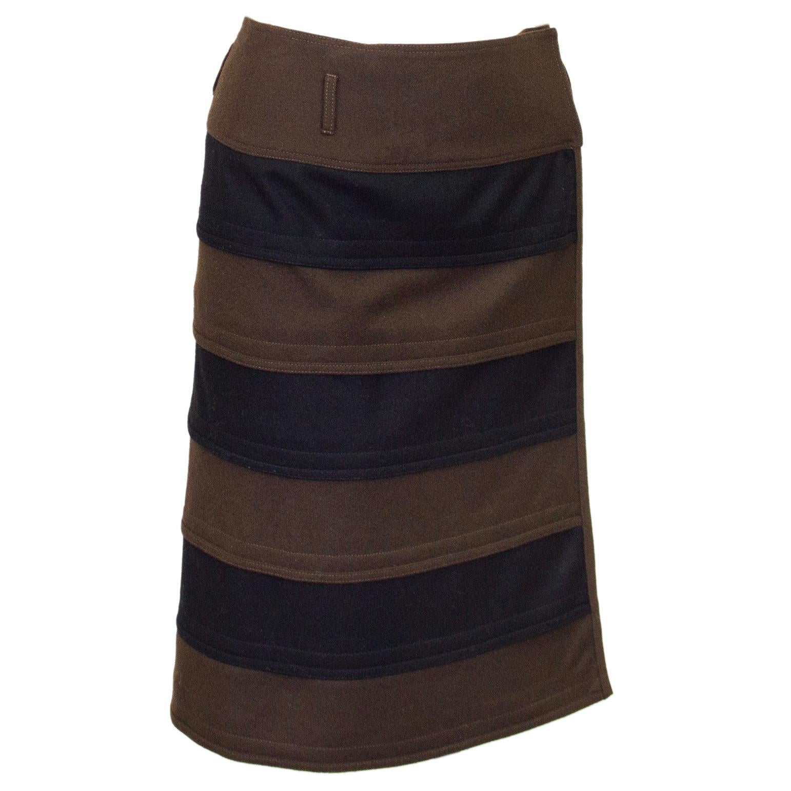 Early 1980s Gianni Versace skirt. The skirt is crafted from overlapping thick horizontal chocolate brown and black felted wool stripes. The skirt sits high on the waist, is wrap style and straight in shape. Tonal top stitching throughout. Belt loops