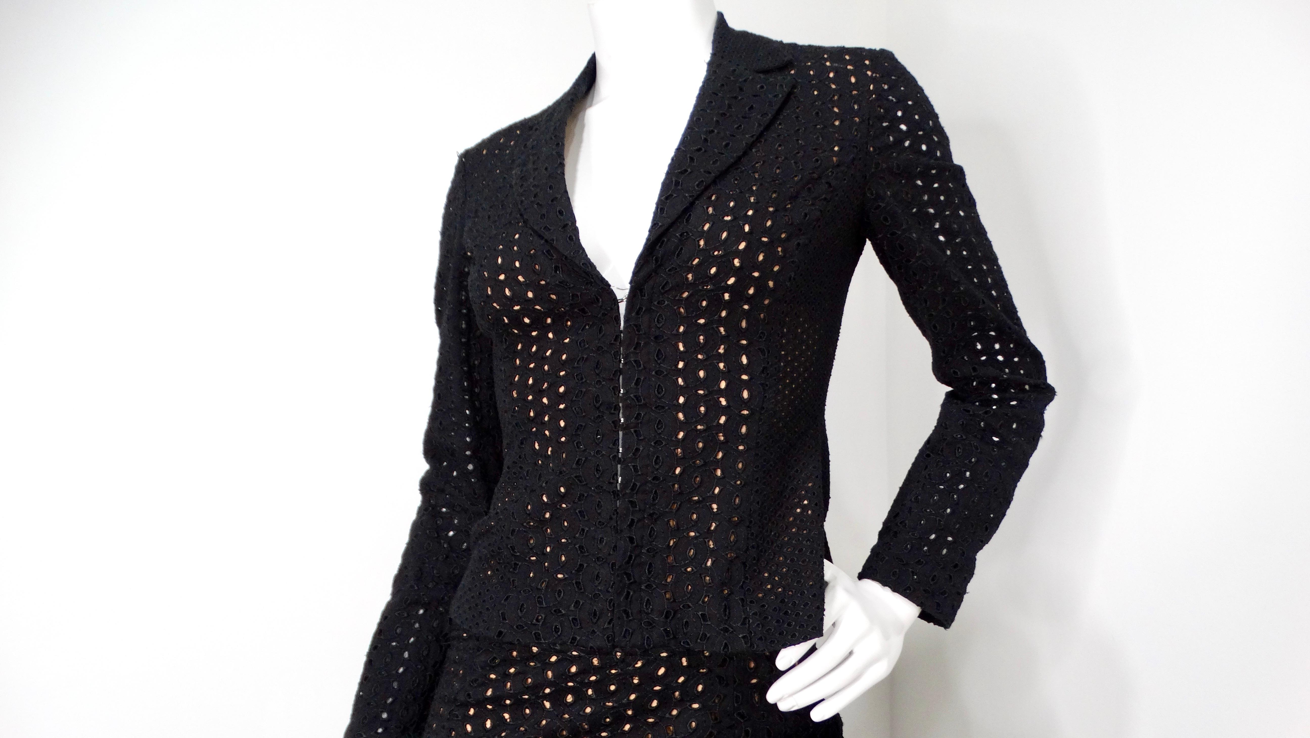 Découvrez l'élégance de la haute couture des années 1980 avec cet ensemble de costume Gianni Versace qui reflète parfaitement l'audace de la mode de l'époque. Le blazer noir à œillets présente des découpes complexes qui créent un étonnant jeu