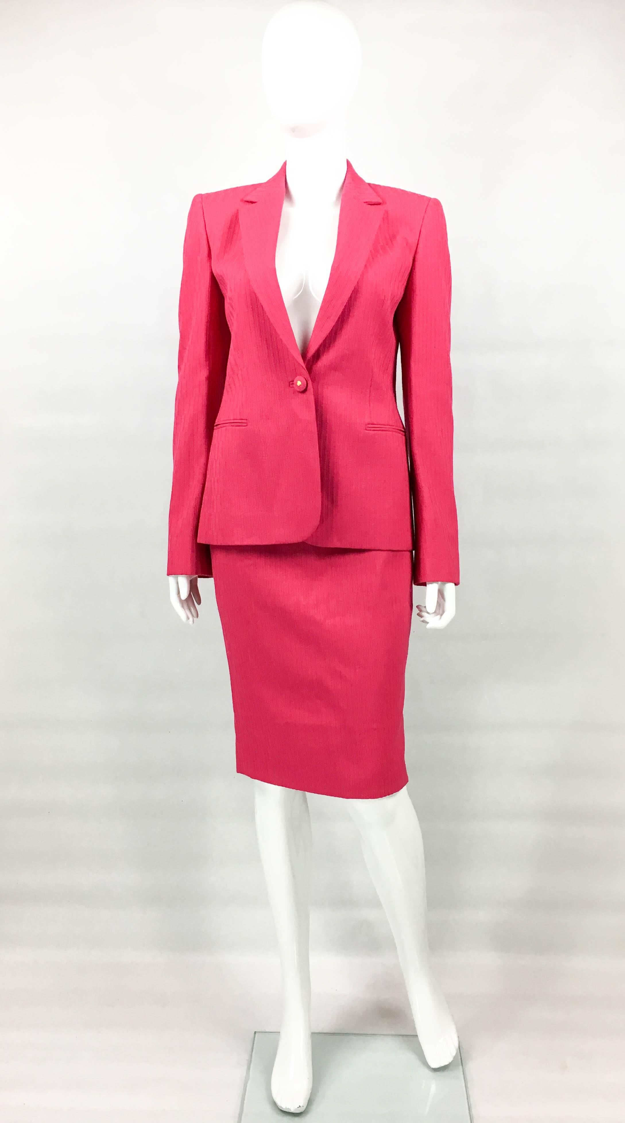 Vintage Gianni Versace Couture Shocking Pink Skirt Suit. This gorgeous ensemble by Gianni Versace dates back from the 1980’s. Made in shocking pink texturized wool, it comprises of a single-breasted jacket and a pencil skirt. The buttons are covered