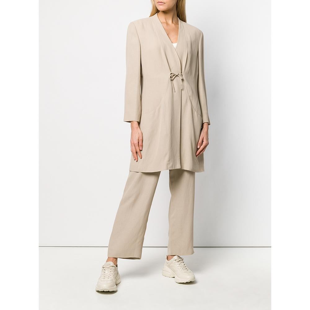 Giorgio Armani beige suit composed by jacket and trousers. The jacket is long, has a V-neckline that ends with a lace-up closure, long sleeves and front pockets; the trousers have a high waist with a straight leg fit.

Years: 80s

Made in Italy
