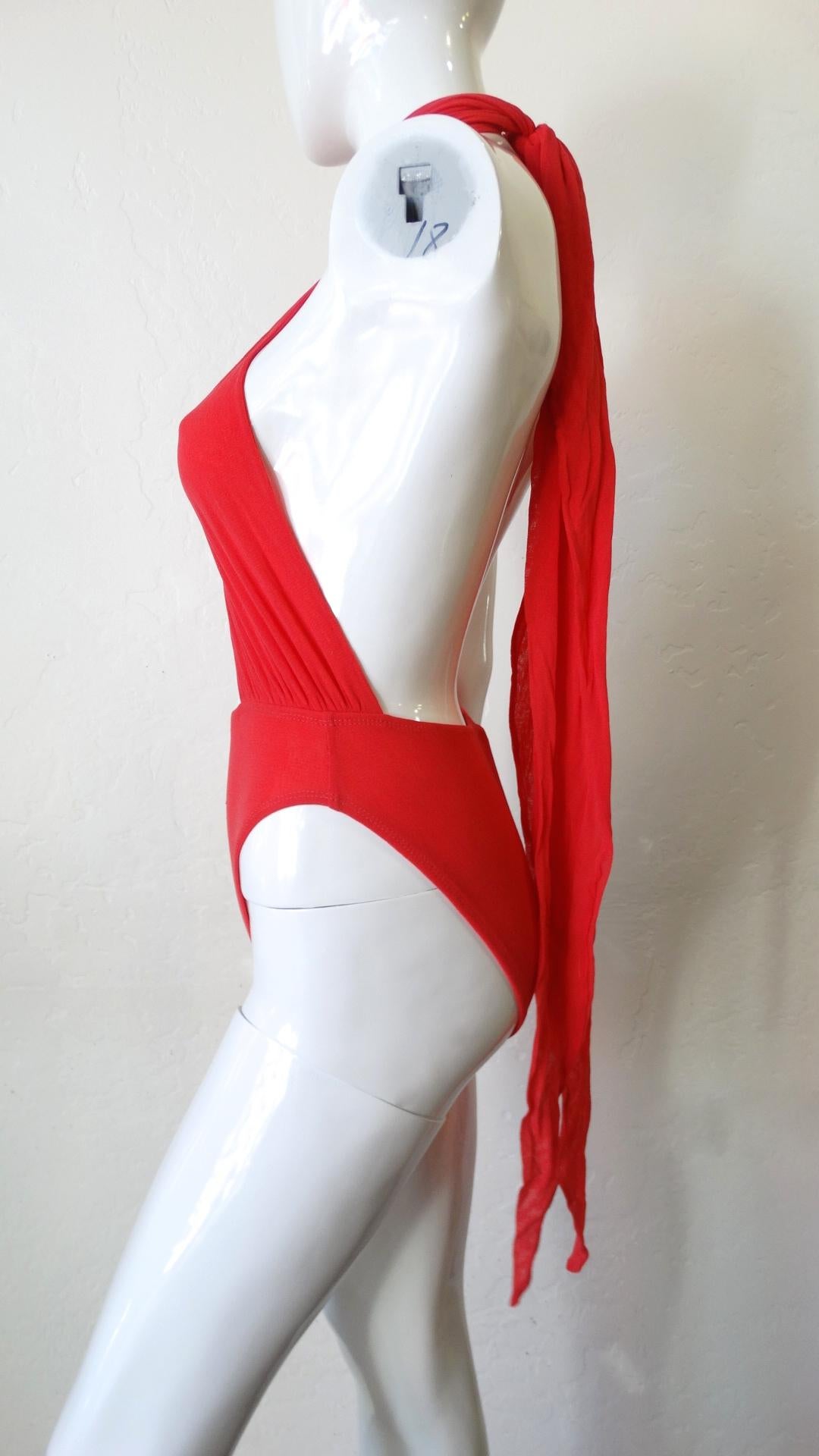 All Eyes On You This Summer! Circa 1980s, this Giorgio di Sant Angelo vibrant red wrap top one piece swimsuit features two wrap ties, allowing you to wear the piece a variety of ways. Bathing suit includes open back, high hip bottoms and is made of