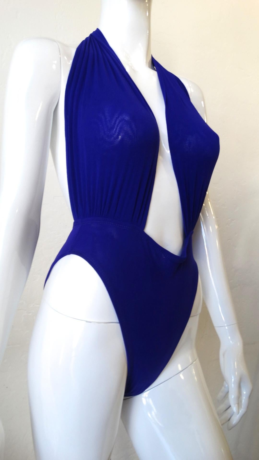 All Eyes On You This Summer! Circa 1980s, this Giorgio di Sant Angelo beautiful midnight blue wrap top one piece swimsuit features two wrap ties, allowing you to wear the piece a variety of ways. Bathing suit includes open back, high hip bottoms and