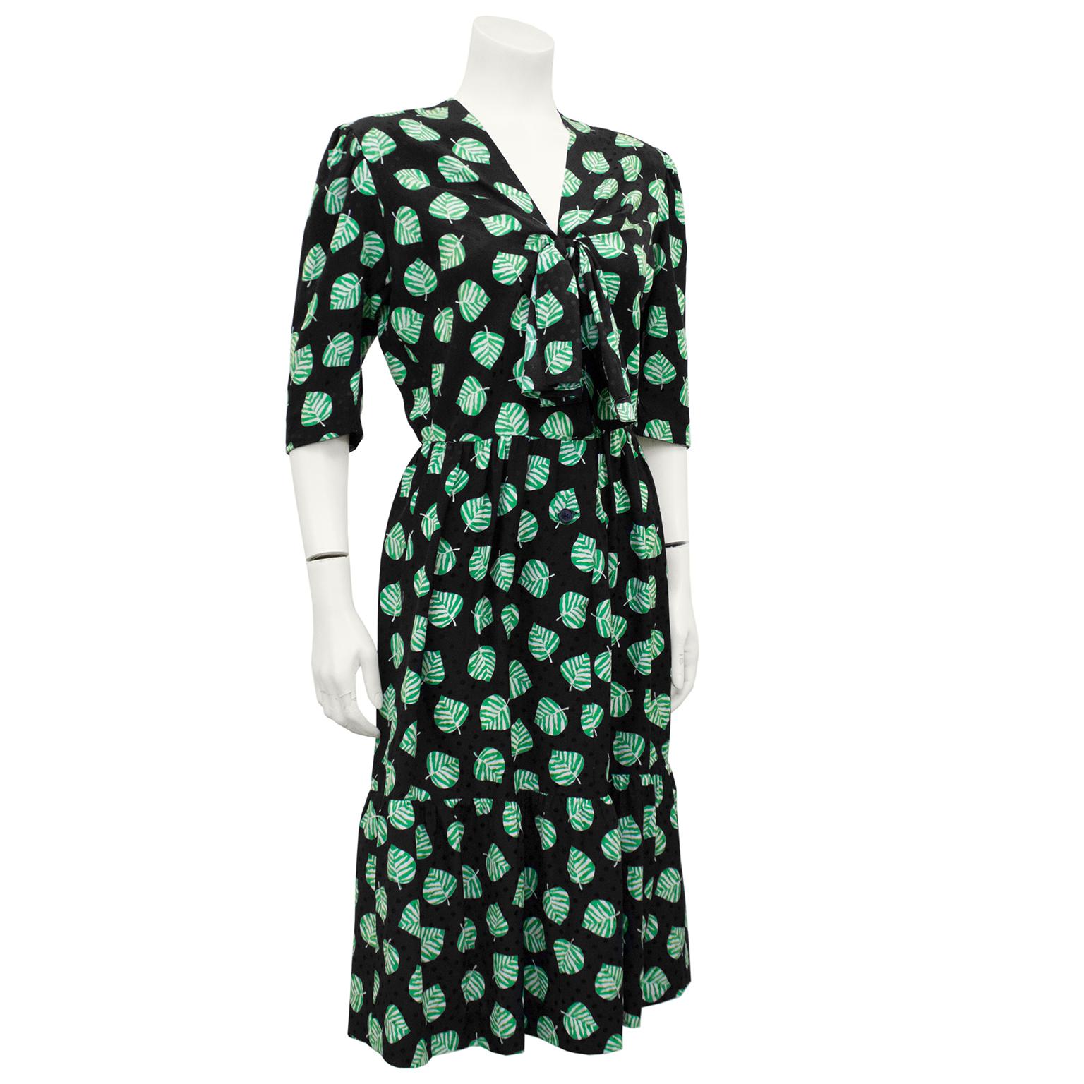 Givenchy dress from the 1980s. Black silk monochromatic jacquard polka dots throughout and contrasting green and white leaves. Small v neckline with twisted tie at bust. Short sleeves, fitted waist and mid length skirt. Excellent vintage condition.