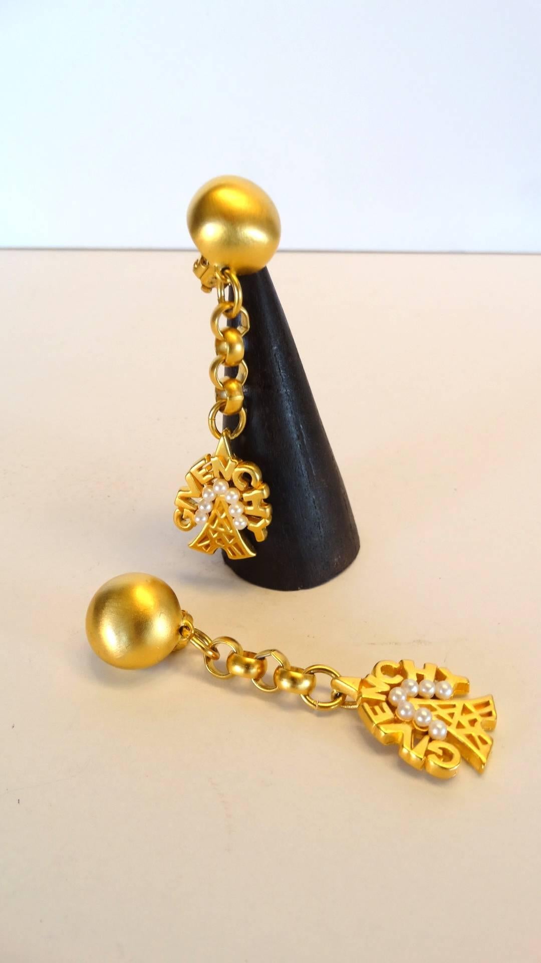 Wonderful gold brushed drop earrings designed by Givenchy! Earring drops down 2.5 inches, the Eiffel tower dangling from the bottom of the chain. The tower is surrounded  by faux pearls.  Made in France both earrings are signed Givenchy Paris 