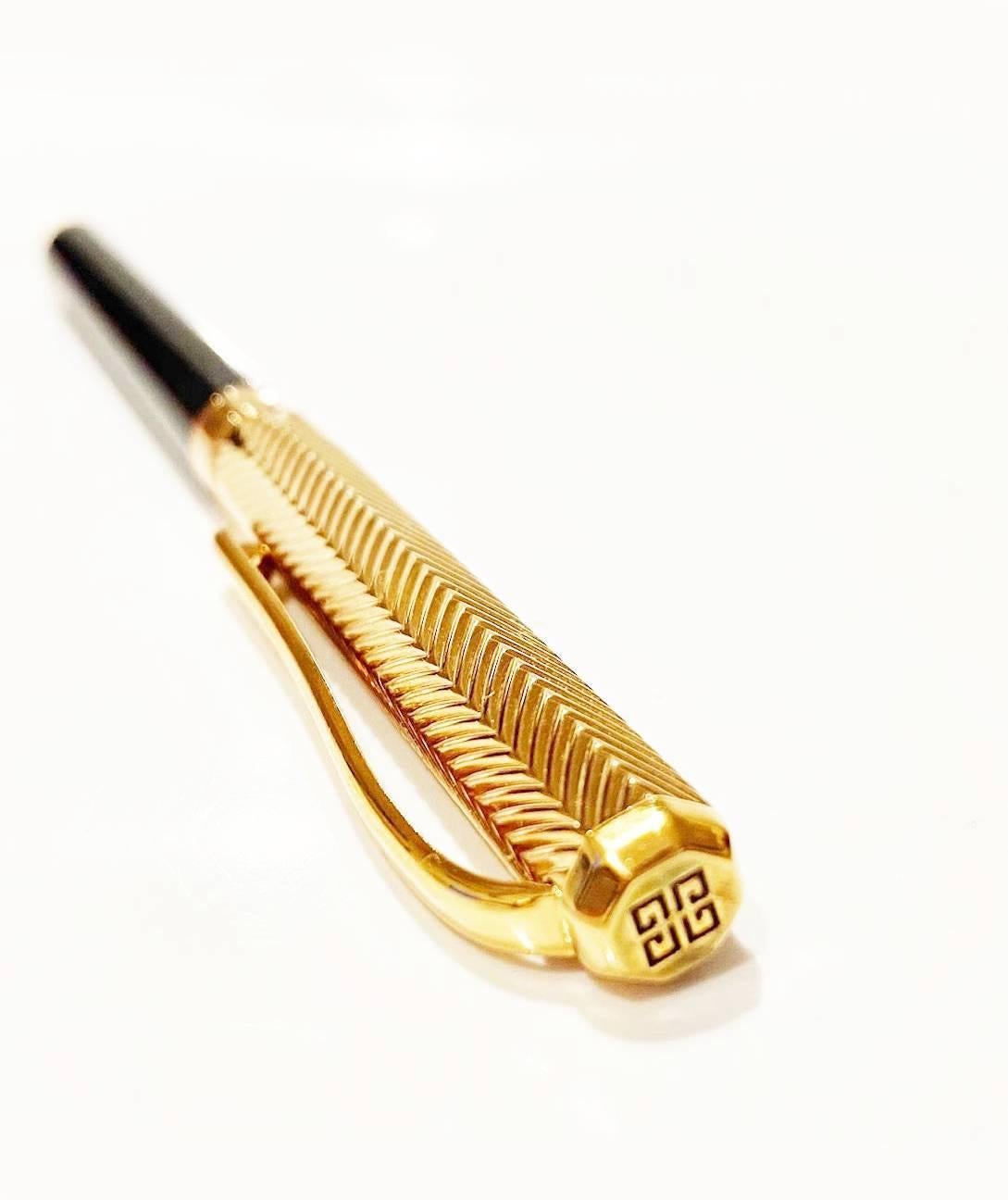 Givenchy ballpoint pen, gold coloured top, twist to open pen, logo on top, logo engraved

Condition: 1980s, very good 