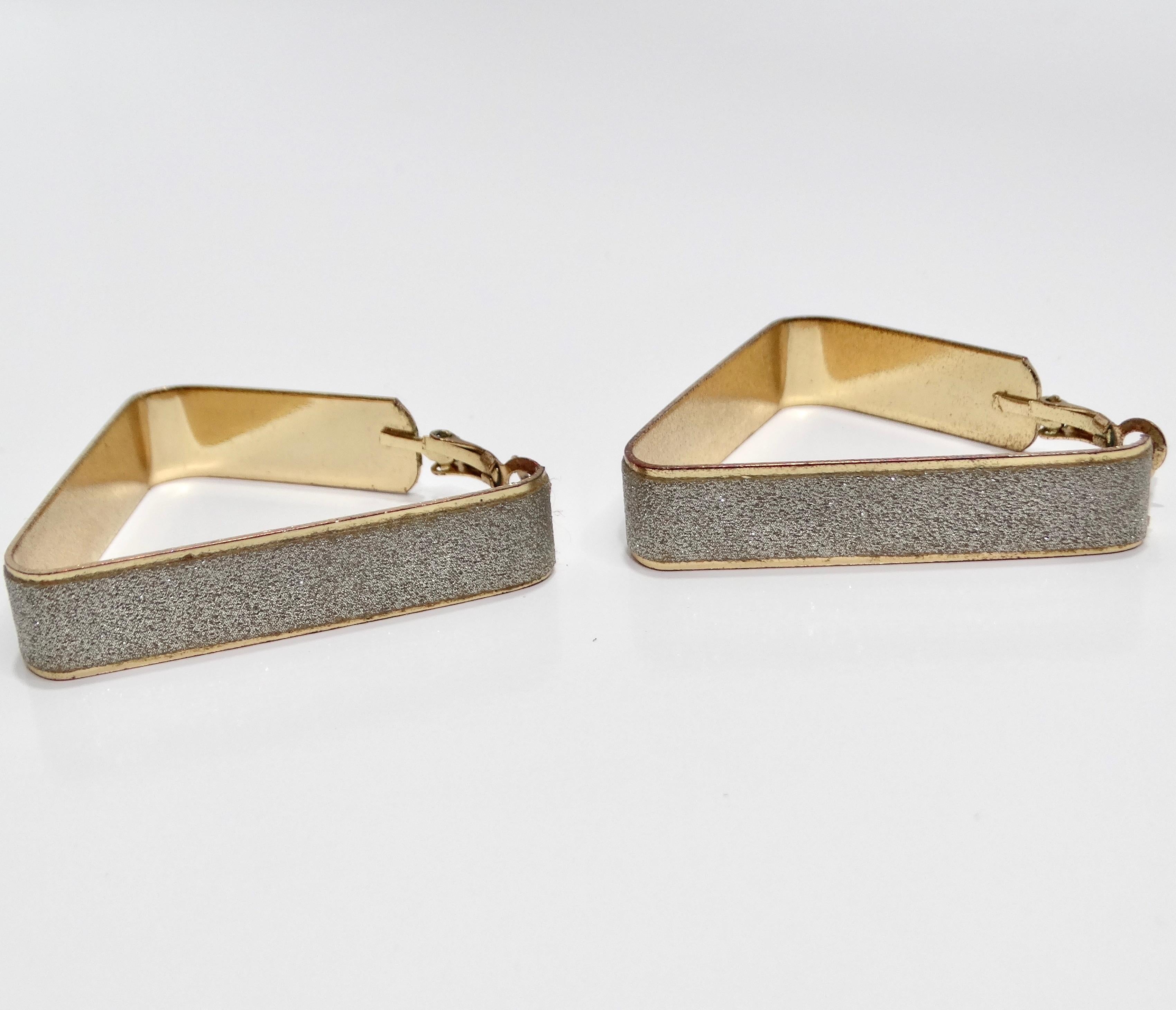 Introducing the 1980s Glitter Triangle Hoop Earrings, a fun and stylish pair of vintage earrings that capture the bold and energetic spirit of the 1980s. These unique geometric hoop earrings are designed in the shape of a triangle, offering a modern