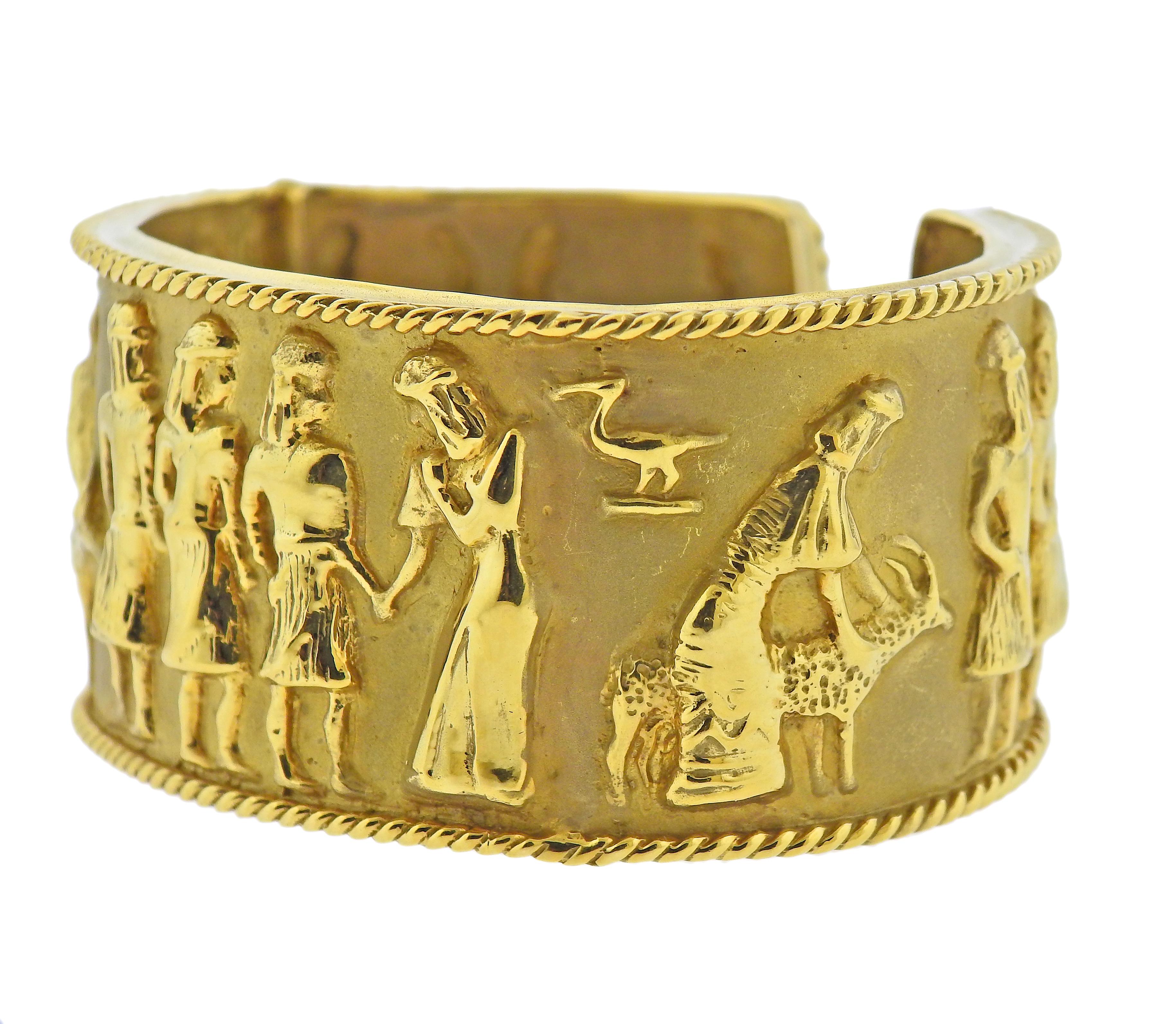 Large 1980s 18k gold cuff bracelet with Egyptian motif ornament. Bracelet will fit approx. 7