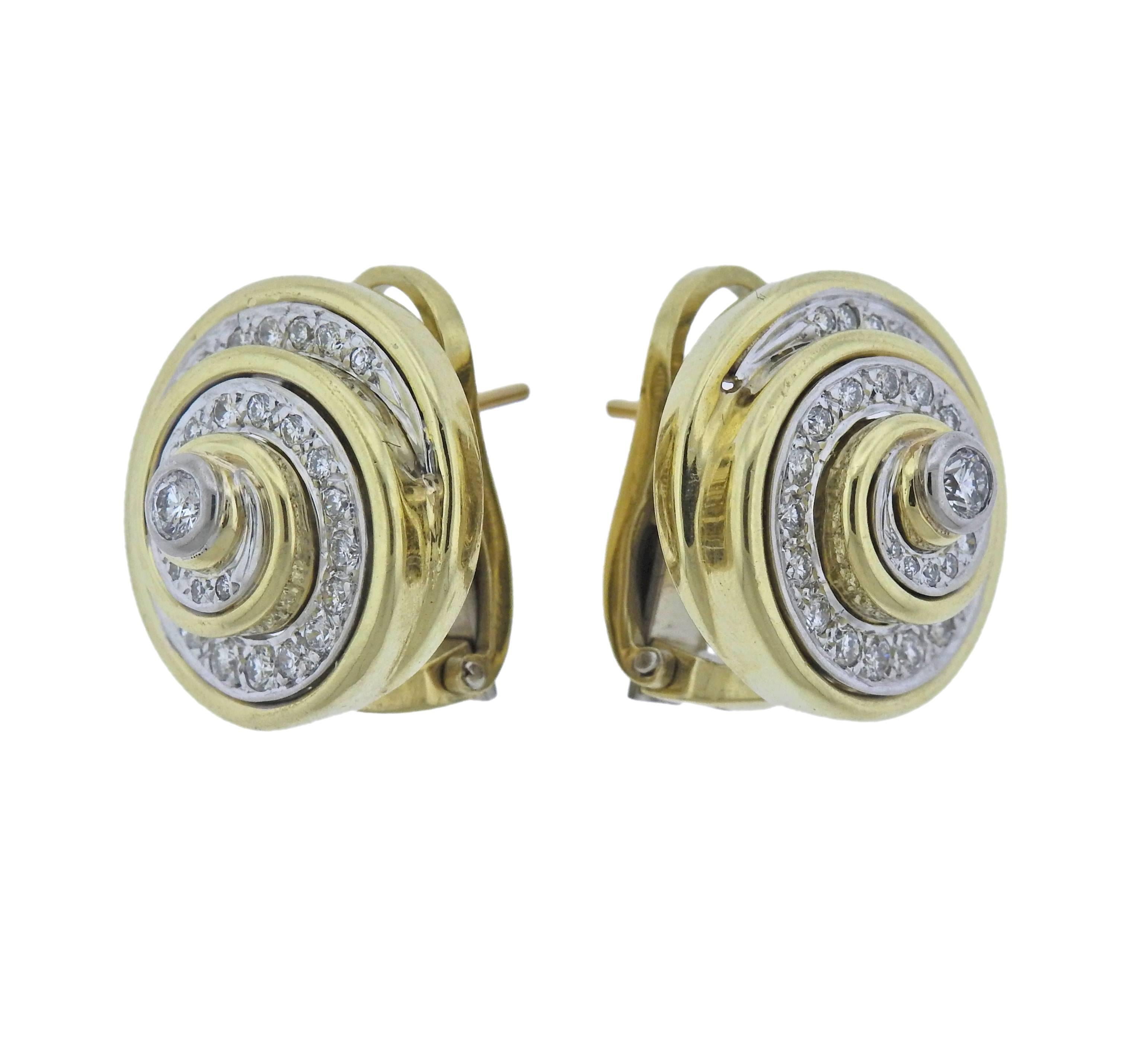 A pair of 18k gold swirl earrings featuring approximately 1.40 ctw of VS/SI- G/H diamonds. Earrings measure 19.5mm in diameter. Marked 18k. Weight is 25.5 grams. 