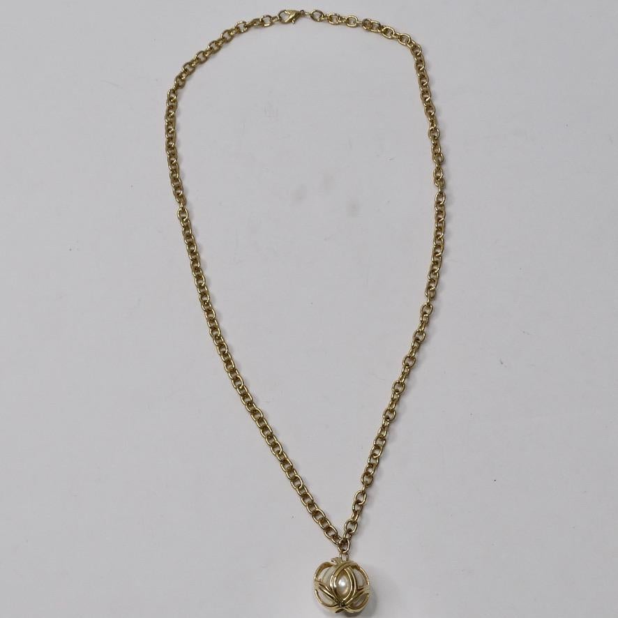 Get your hands on this timeless and elegant 1980s faux pearl pendent necklace! The perfect layering piece to add to your collection, this necklace features a faux pearl encased in a gold tone cage motif. This is such a an elegant and unique style