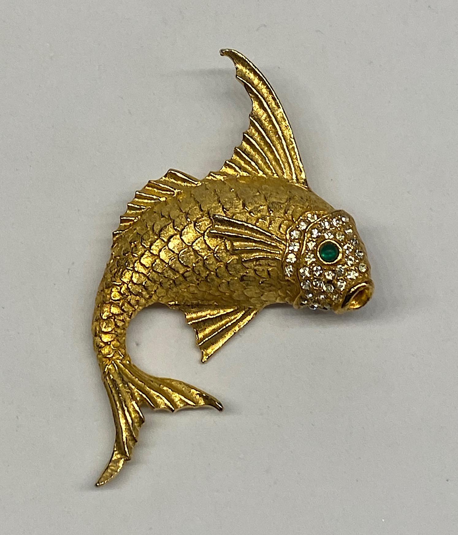 A beautifully made three dimensional fish brooch from the 1980s. The quality of the piece is excellent with scales carefully executed. The face is set with pave' rhinestones and a green glass cabochon for the eye. gold plate in a lovely rich gold