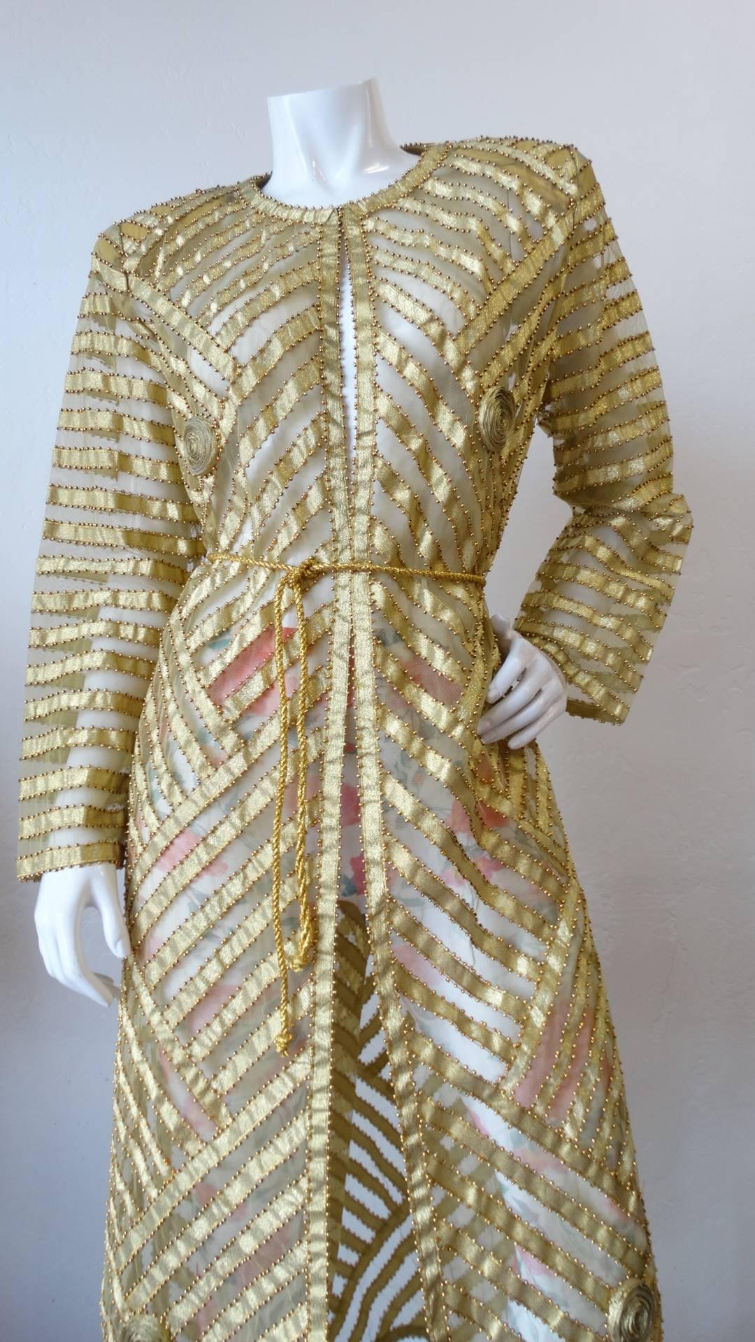 Amazing 1980s beaded gold dress from Tan-Chho! Sheer rayon fabric contrasted with gold lame chevron striping all over! Gold beading along each of the stripes. Cinches in at the waist perfectly with matching gold cord. Rolled, gold fabric flower